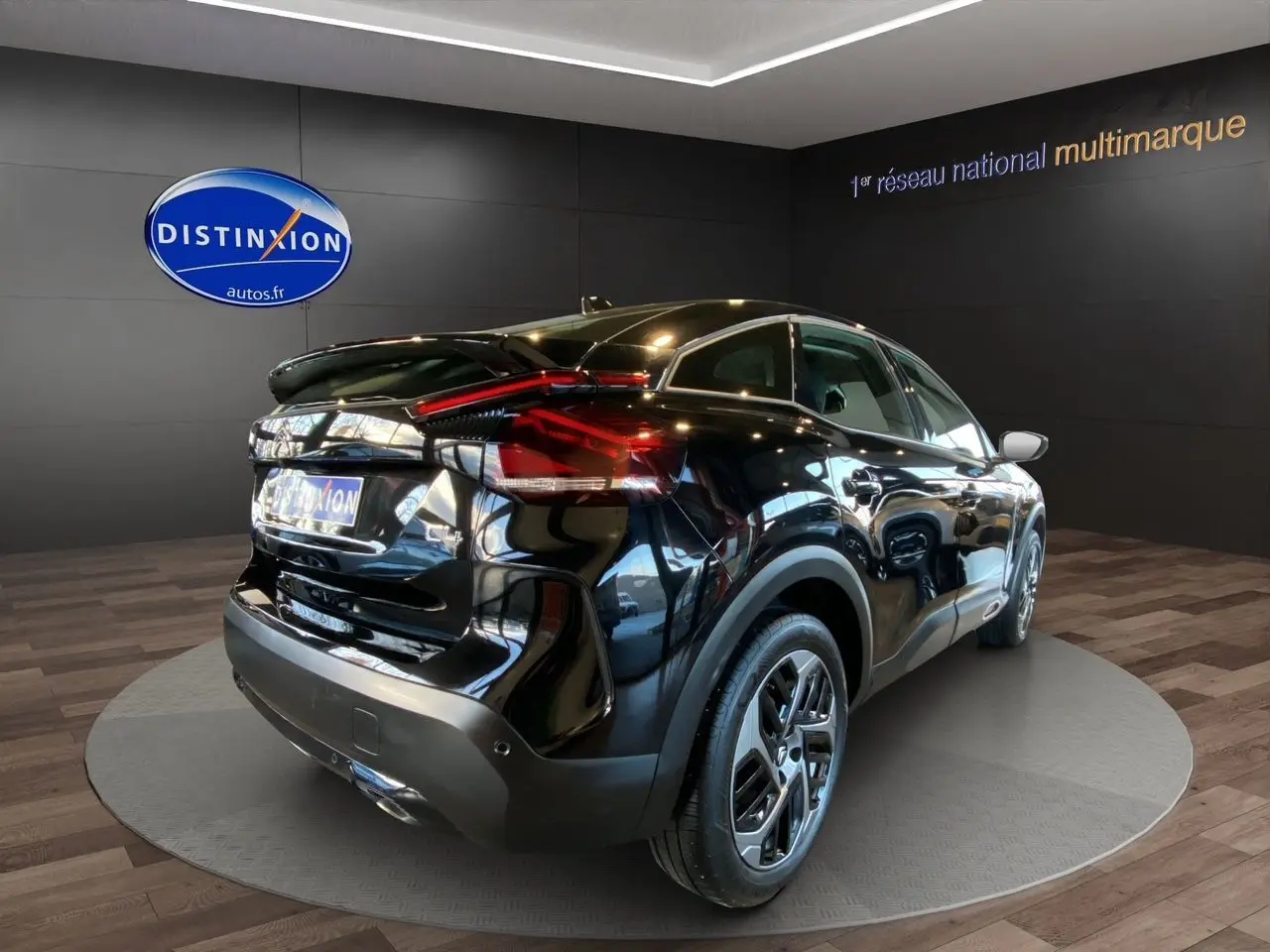 Vue 3/4 arrière droite d'une Citroën C4 2023 noire Perla Nera avec feux arrière LED et jantes alliage.