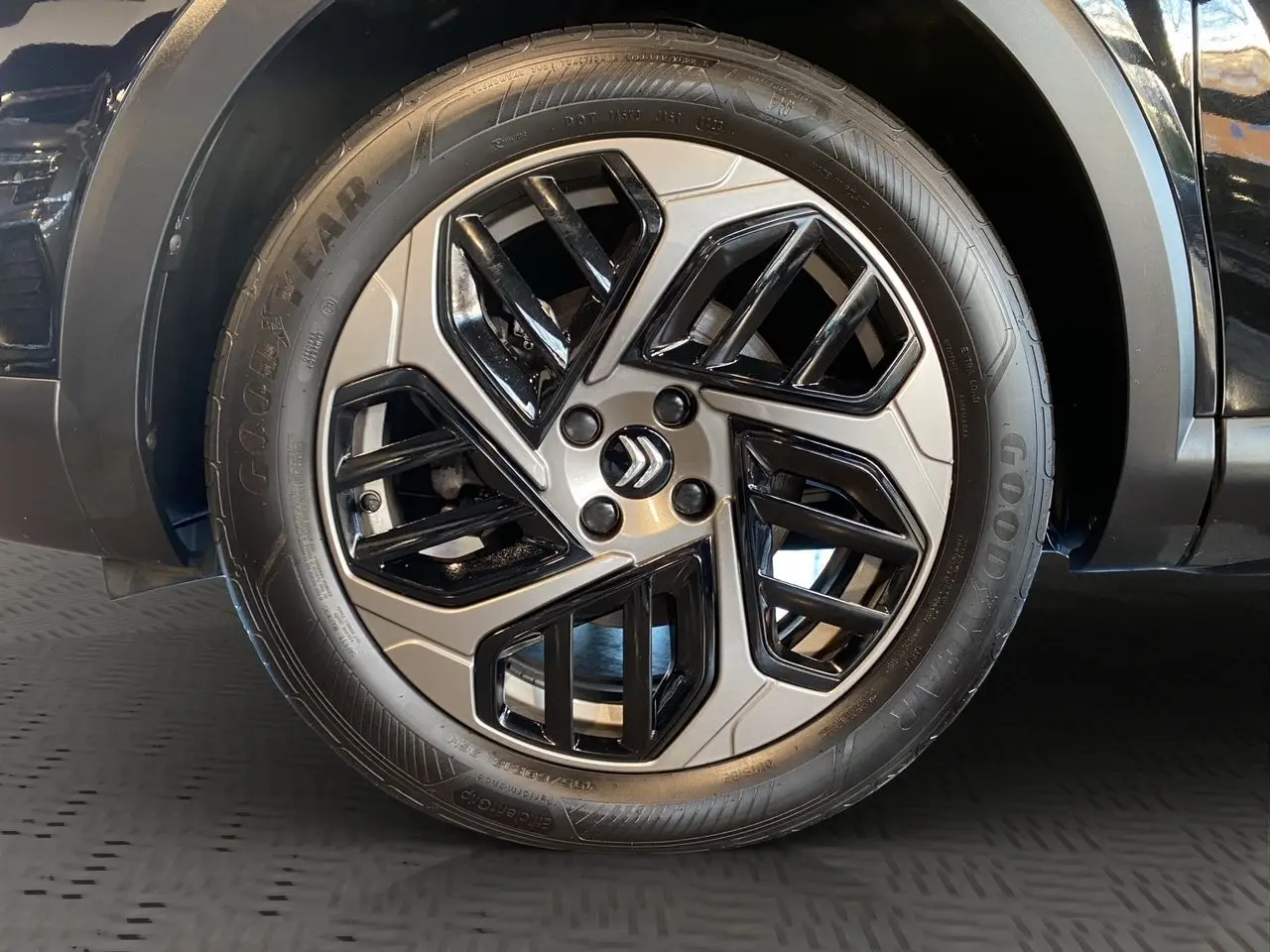 Gros plan sur la roue arrière droite d'une Citroën C4 noire Perla Nera, soulignant le pneu Goodyear et l'arche de roue.