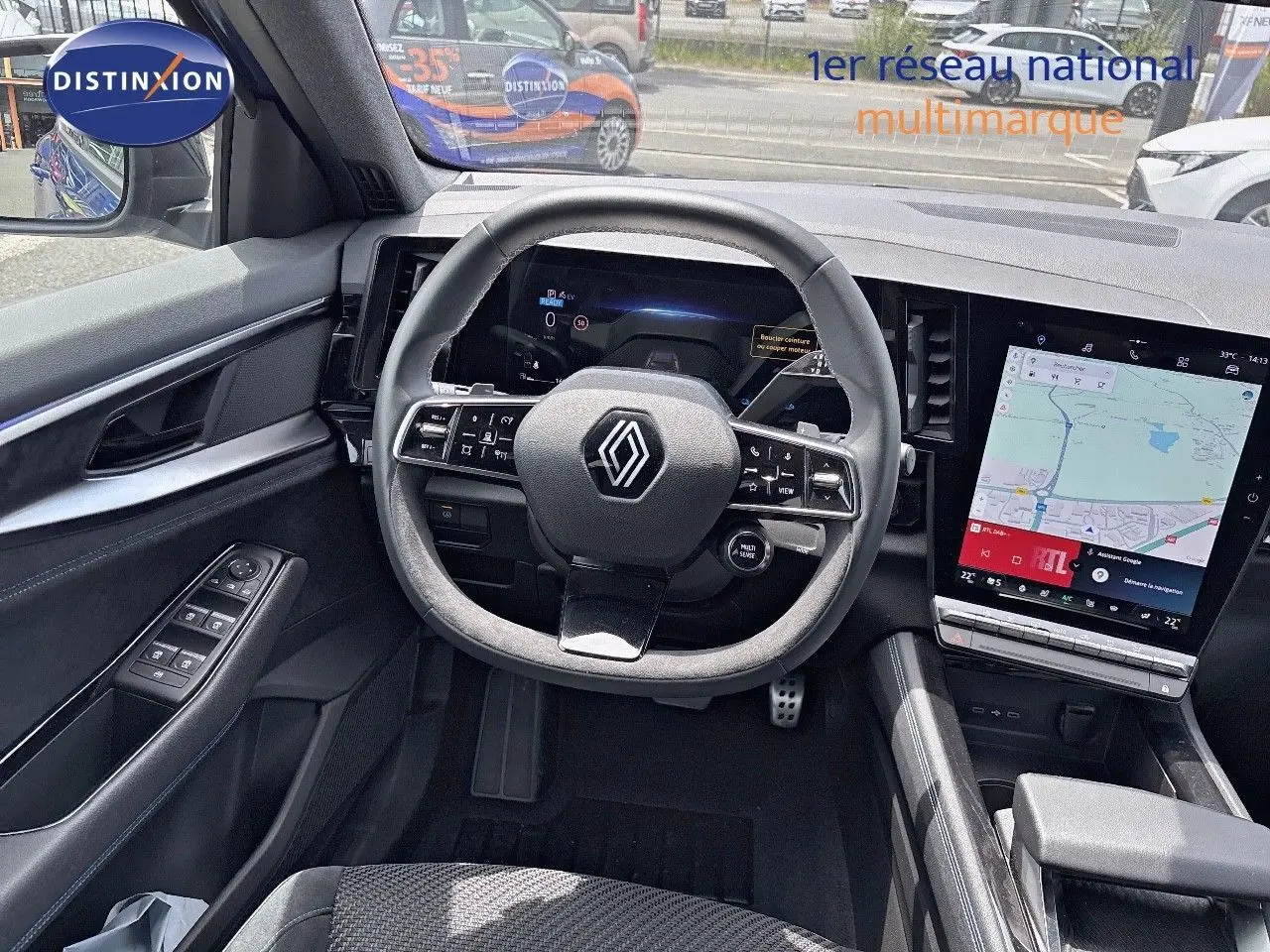 Vue intérieure du tableau de bord du Renault Austral 2024 hybride, avec volant multifonction et écran tactile GPS.