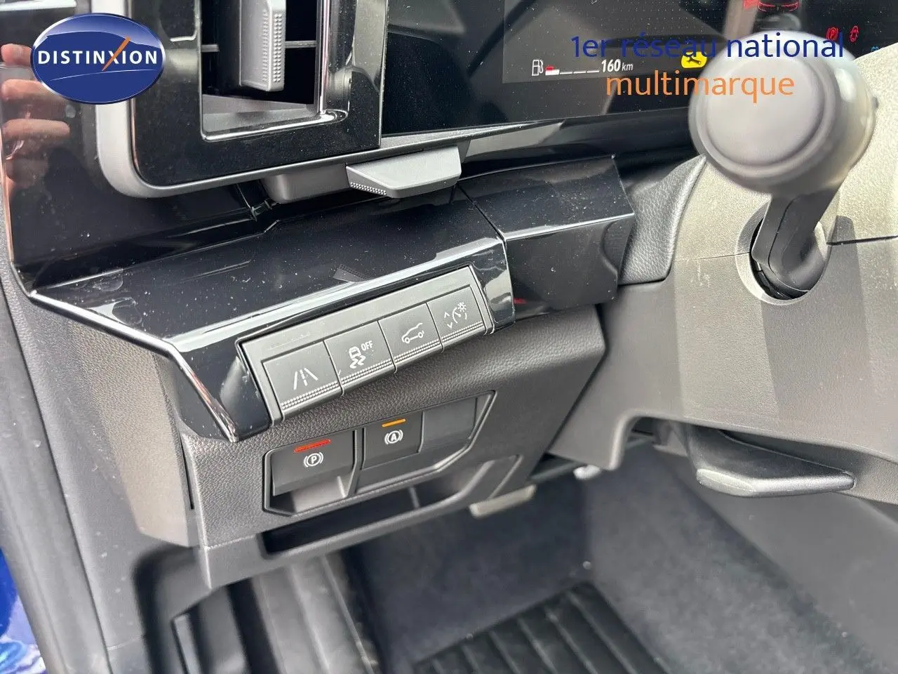 Vue intérieure du tableau de bord côté gauche du Renault Austral bleu iron 2024, avec commandes d'assistance et frein électronique.