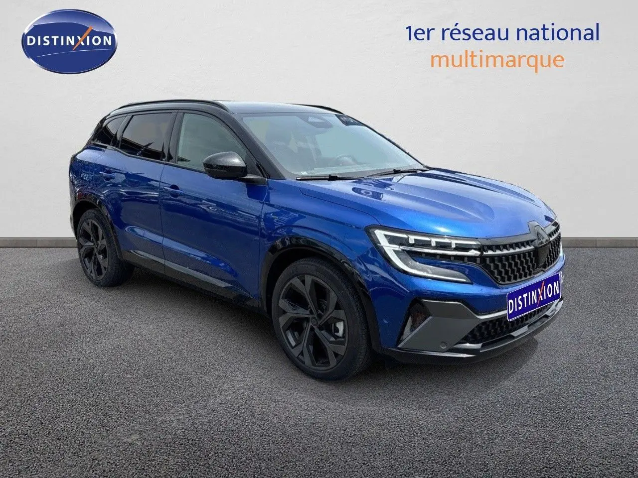 Renault Austral 2024 bleu Iron avec toit noir, vue 3/4 avant droit mettant en valeur ses optiques LED et jantes noires.