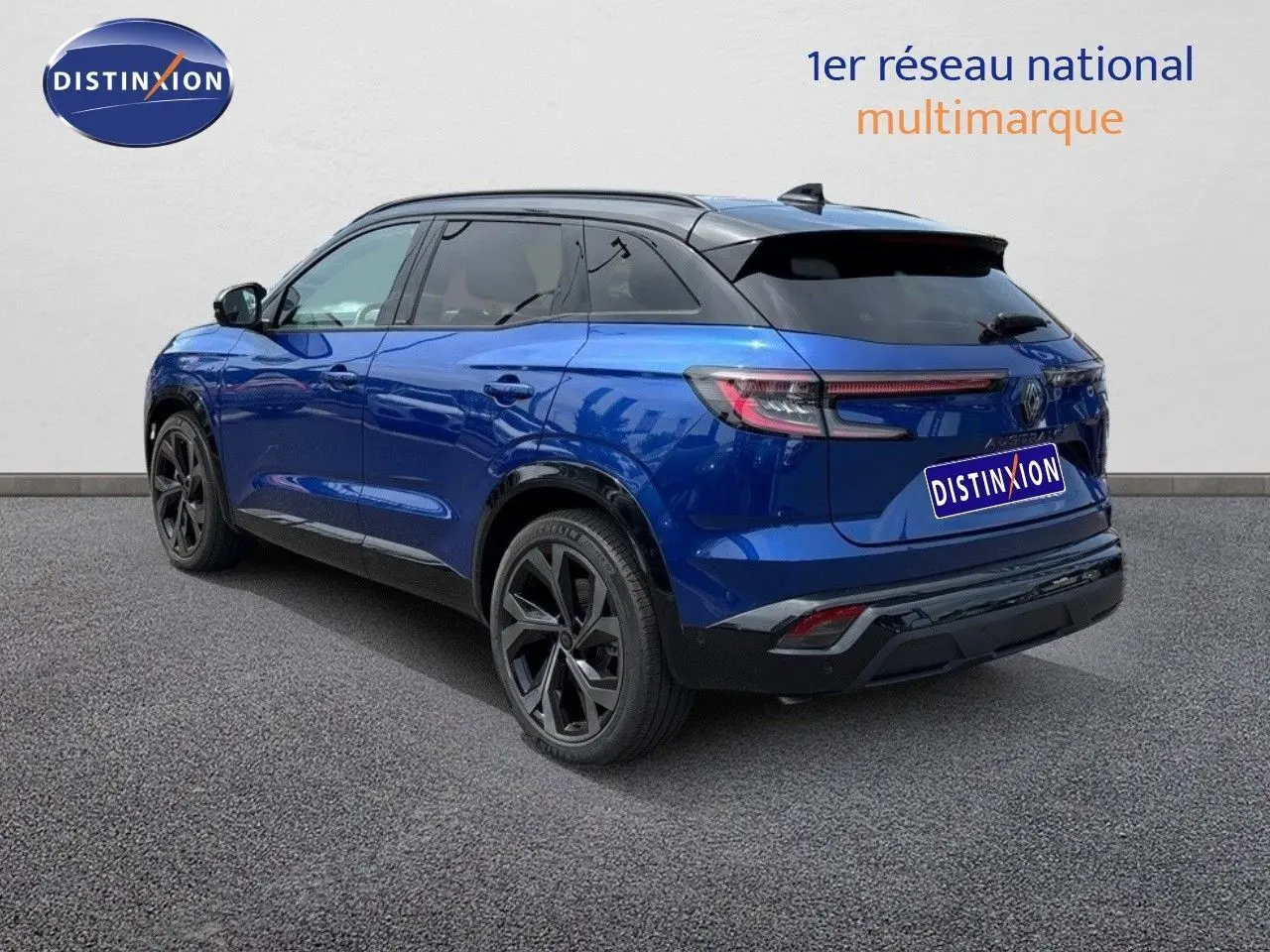Vue 3/4 arrière droite du Renault Austral 2024 bleu Iron avec toit noir et jantes noires distinctives.