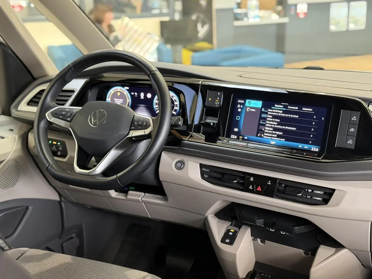 Vue intérieure côté conducteur du tableau de bord beige et noir du Volkswagen California T7 avec volant cuir multifonction.