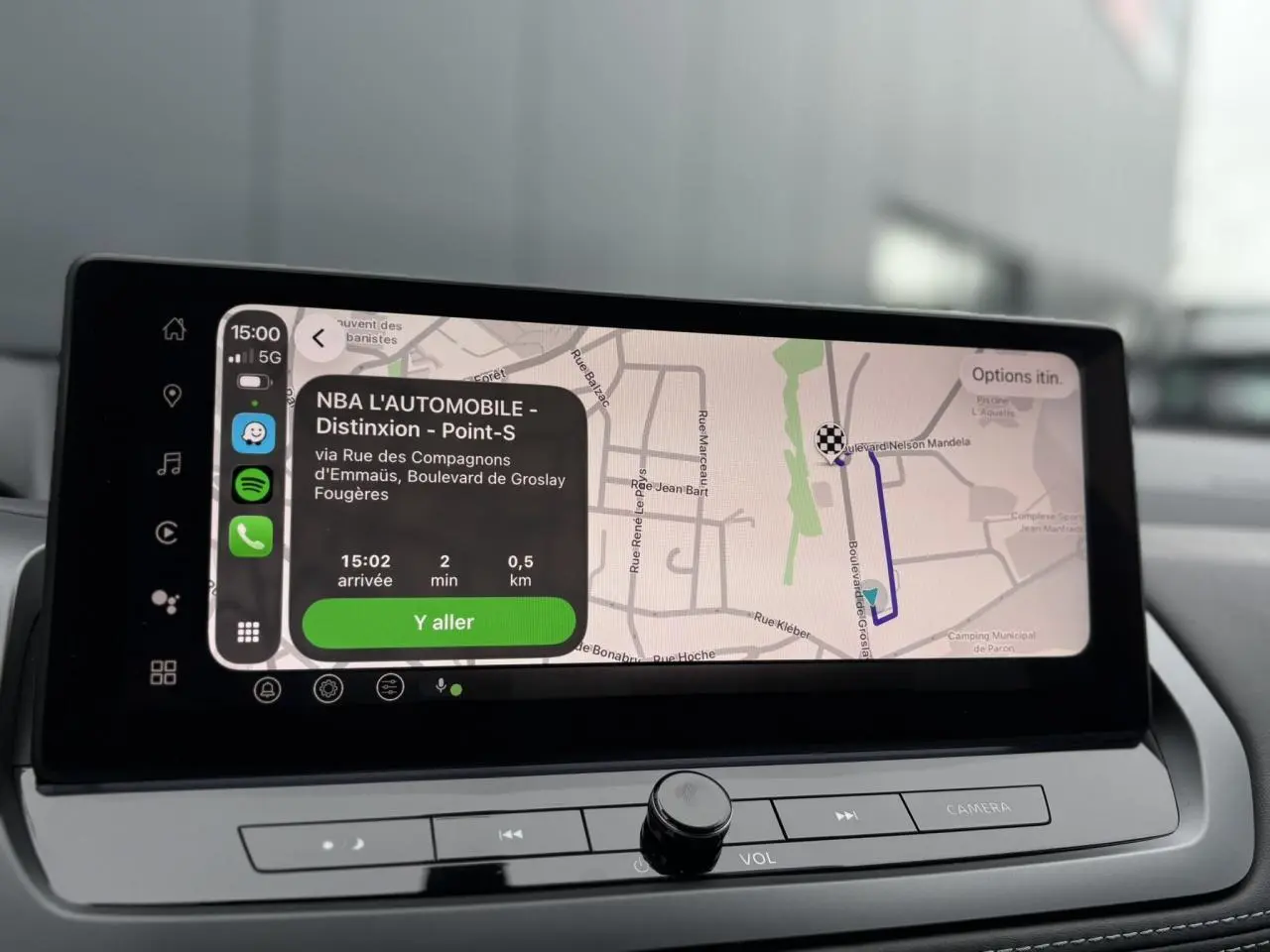 Vue intérieure du tableau de bord du Nissan Qashqai 2024 avec écran tactile de navigation affichant un itinéraire.