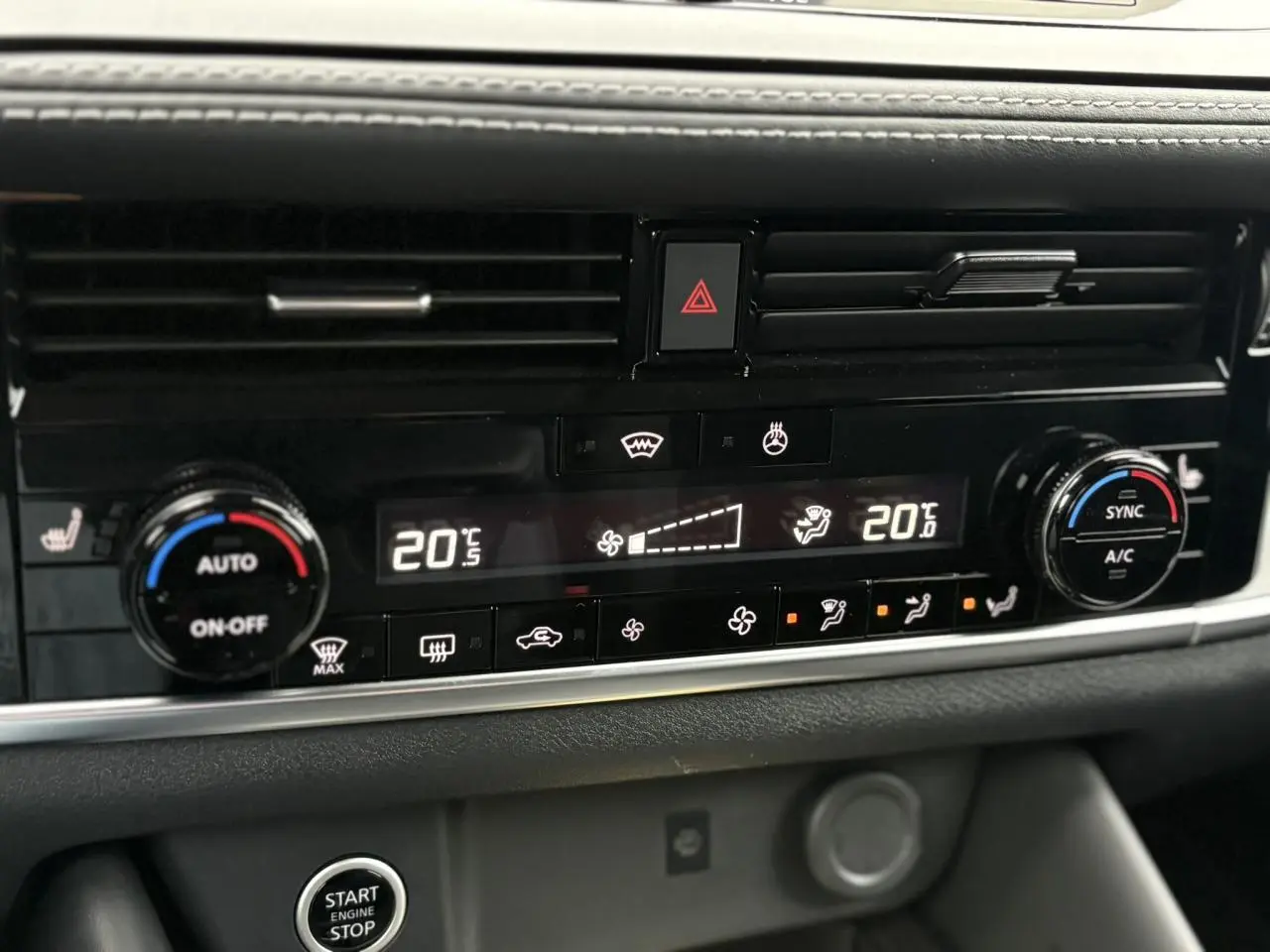 Gros plan sur la console centrale du Nissan Qashqai 2024, affichant la climatisation automatique bi-zone et les commandes chauffantes.