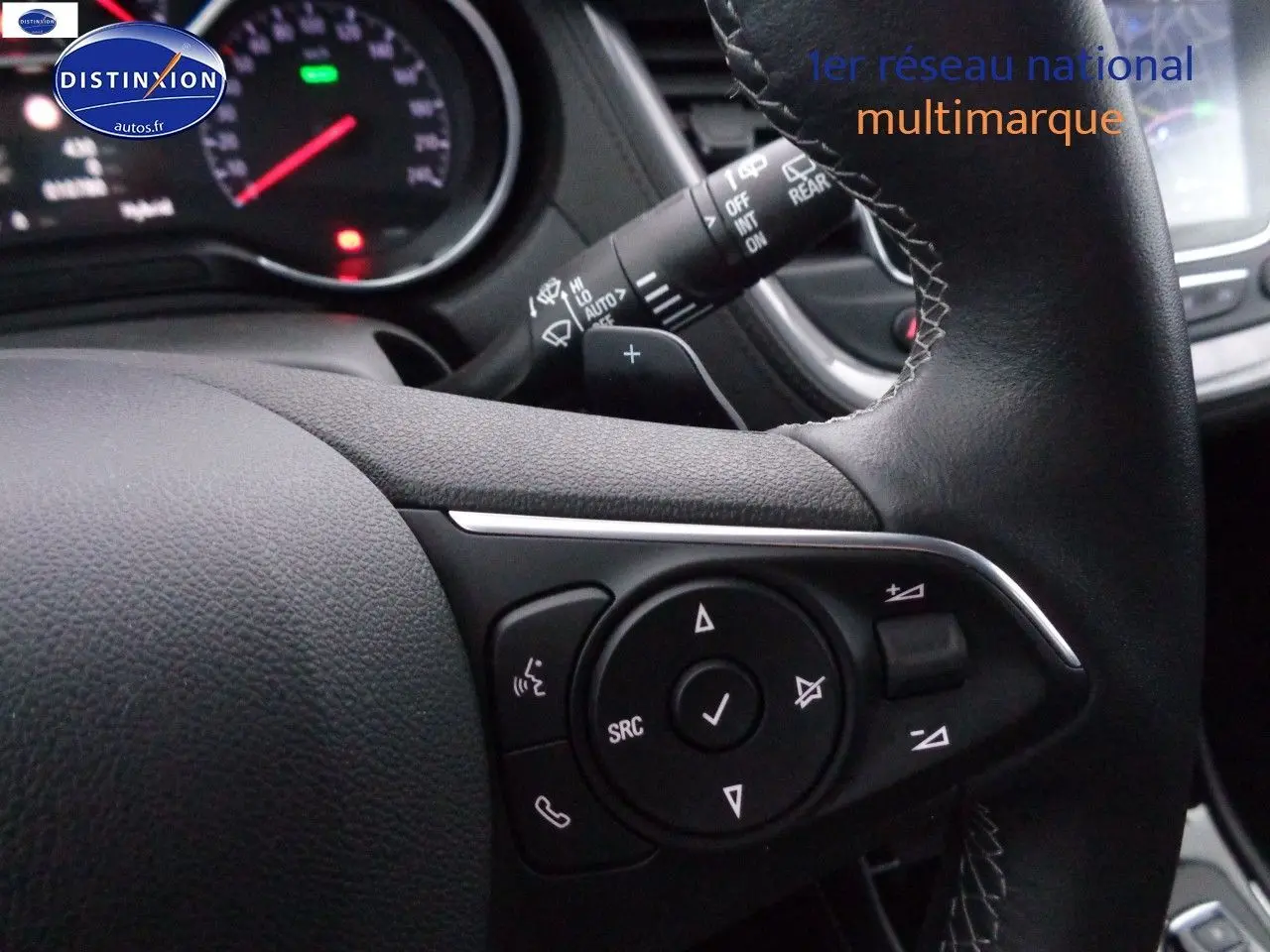 Gros plan sur les commandes du volant en cuir noir de l'Opel Grandland X blanc nacré hybride rechargeable.