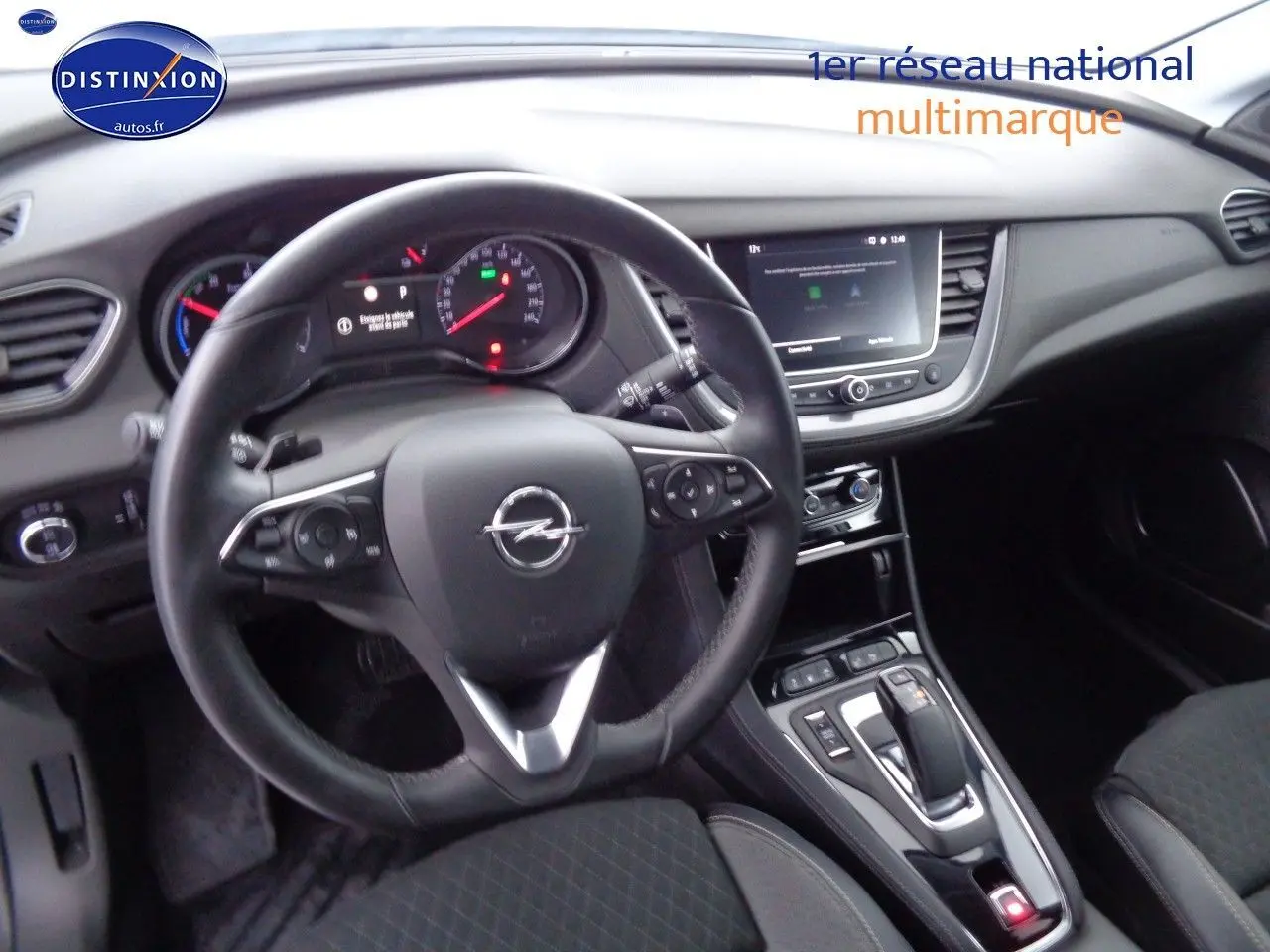 Vue intérieure du tableau de bord et volant noir de l'Opel Grandland X hybride rechargeable, avec console centrale et écran tactile.