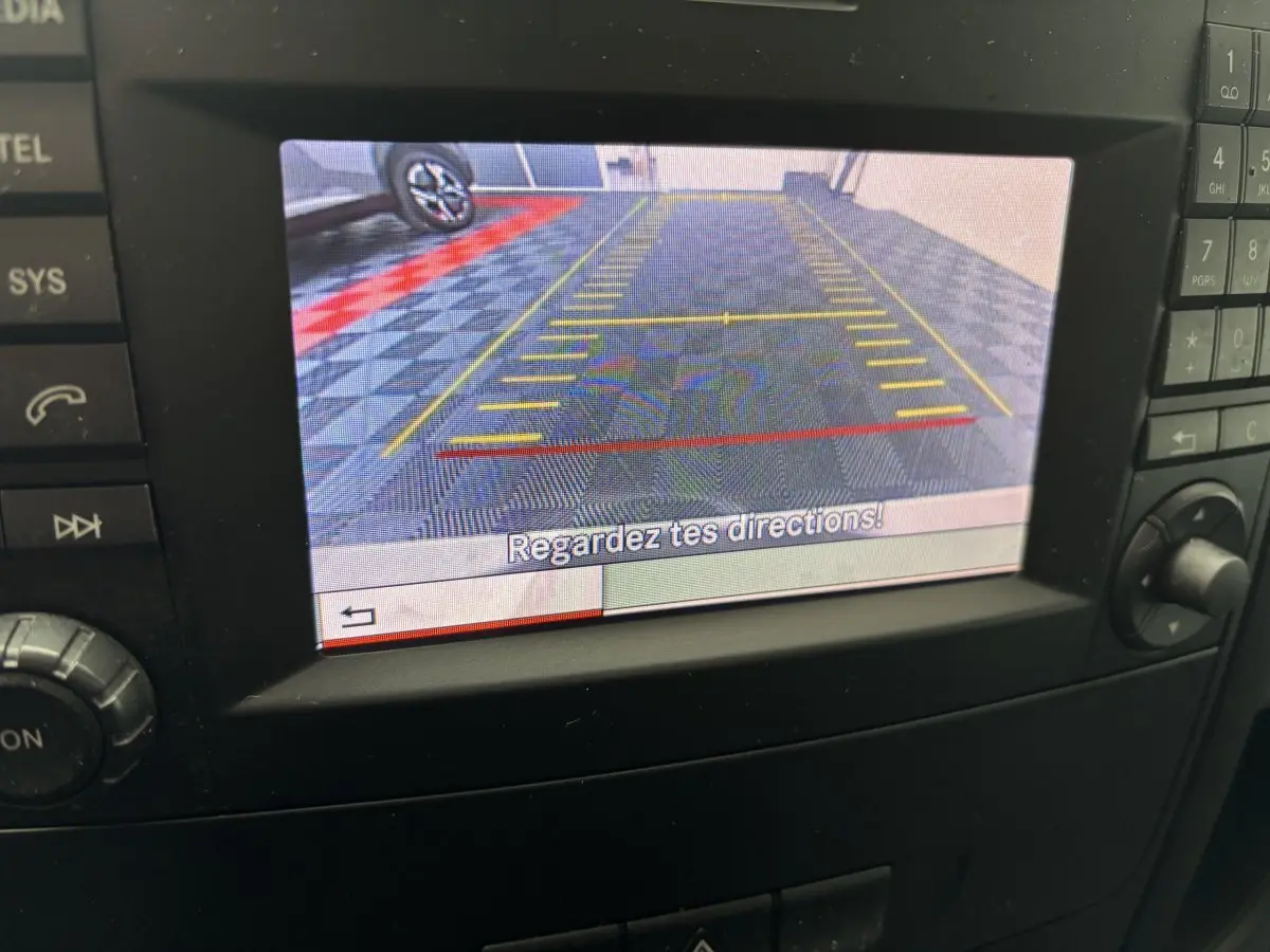 Vue de l'écran de caméra de recul du Mercedes Vito blanc 111 CDI Compact, affichant les lignes de guidage jaunes et rouges.