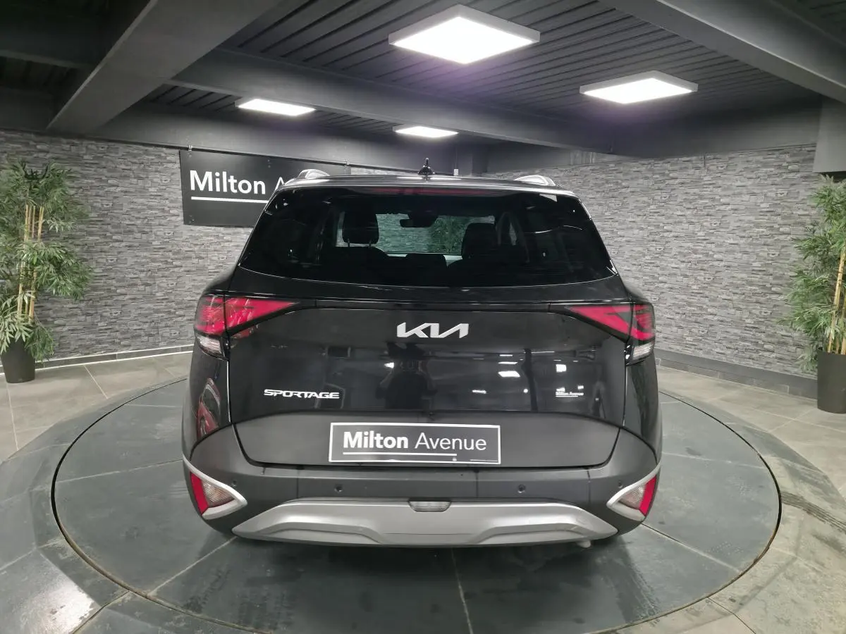 Vue arrière d'un Kia Sportage noir 2022 avec feux arrière LED et bouclier argenté en showroom.