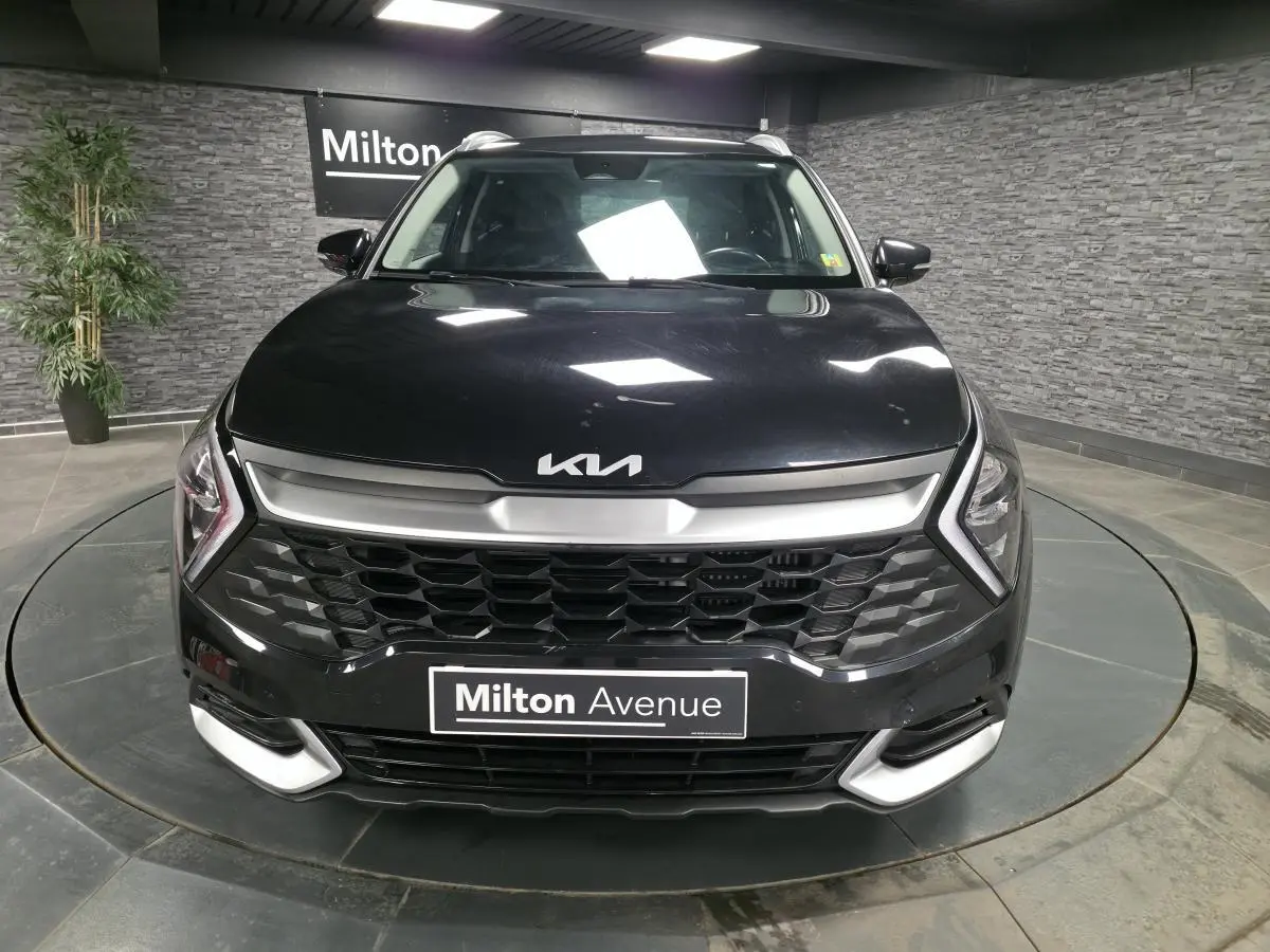 Vue frontale d'un Kia Sportage noir 2022 avec calandre noire laquée et inserts argentés sur boucliers.