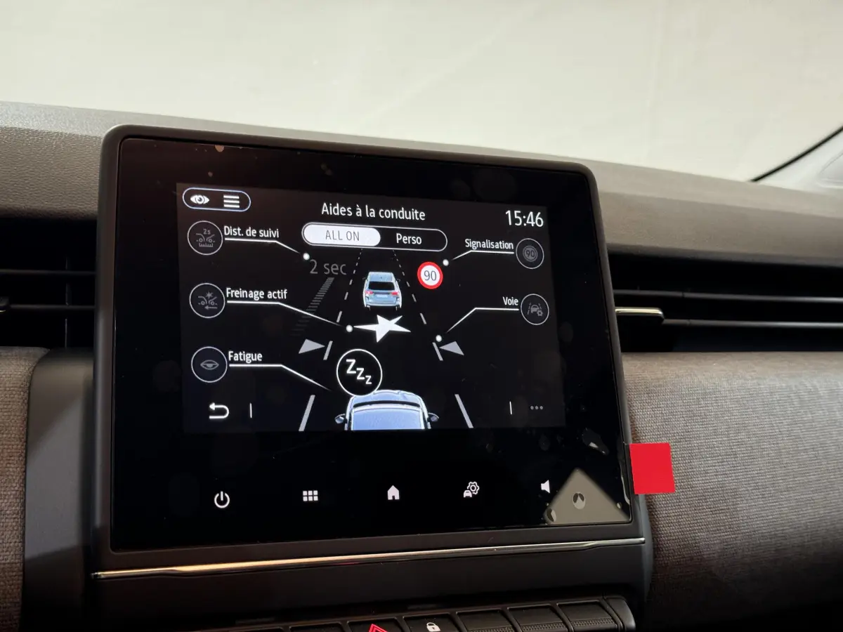 Écran tactile central affichant les aides à la conduite dans l’habitacle d’une Renault Clio gris clair 2025.