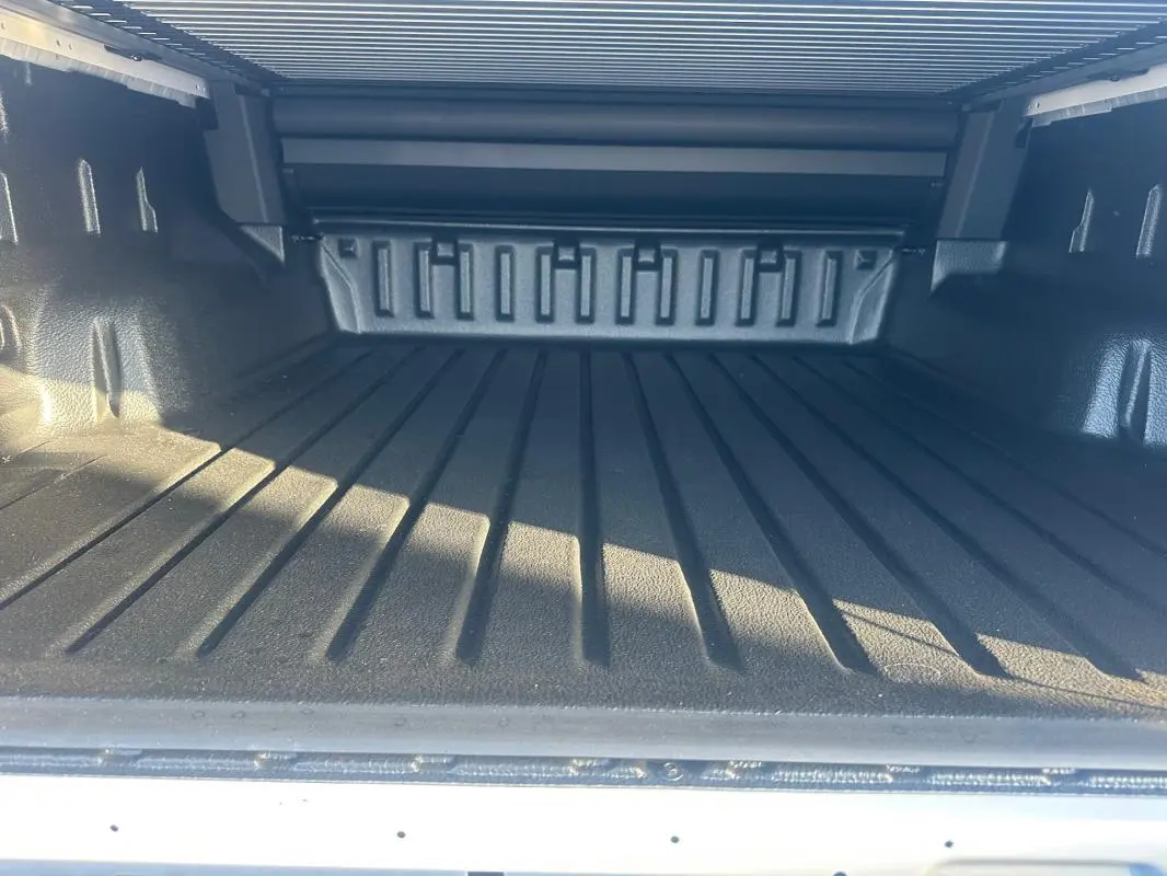 Vue rapprochée de la benne noire du Ford Ranger Raptor blanc 2025, soulignant son espace de chargement robuste.