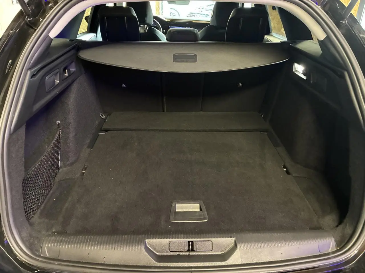 Coffre ouvert de la Peugeot 308 SW noire, vue arrière montrant l’espace de chargement et la plage arrière.