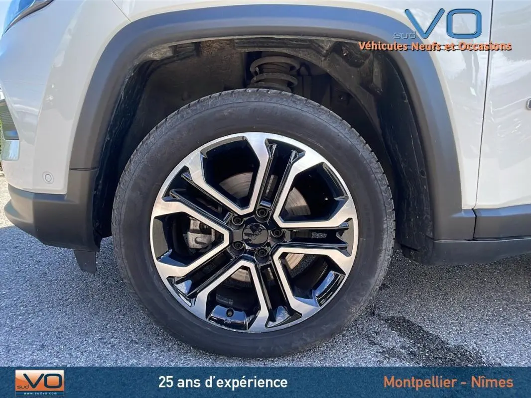 Gros plan sur la jante alliage 18 pouces noire et argent du côté avant gauche d’un Jeep Compass blanc 2024.