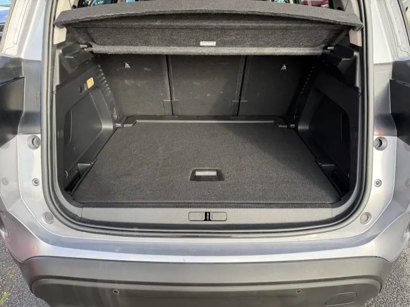 Coffre ouvert vu de l'arrière d'un Citroën C5 Aircross gris 2024, montrant un espace de chargement propre et spacieux.