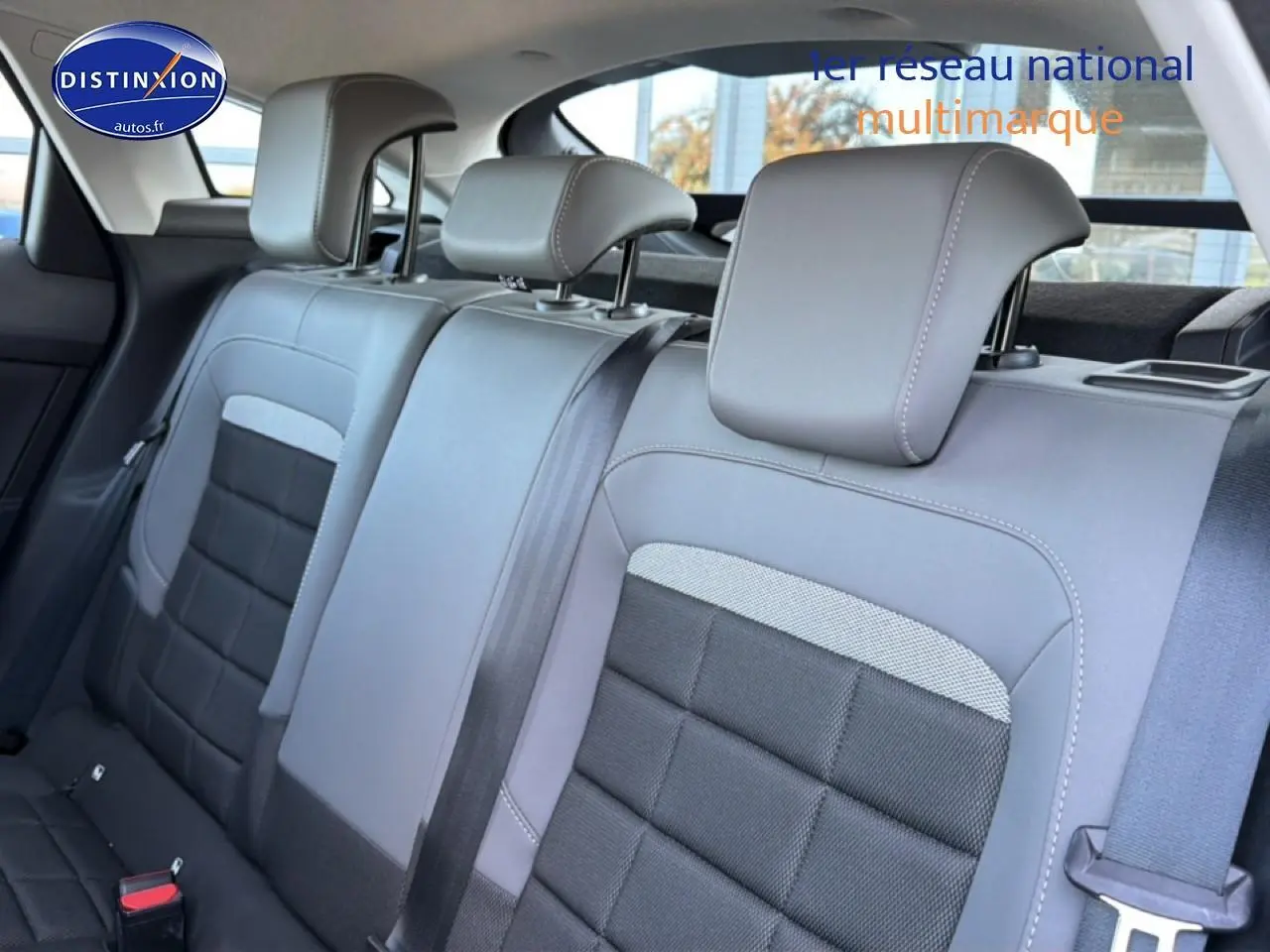 Vue intérieure de la banquette arrière gris foncé et noir de la Citroën C4 électrique 2025 avec appuie-têtes réglables.