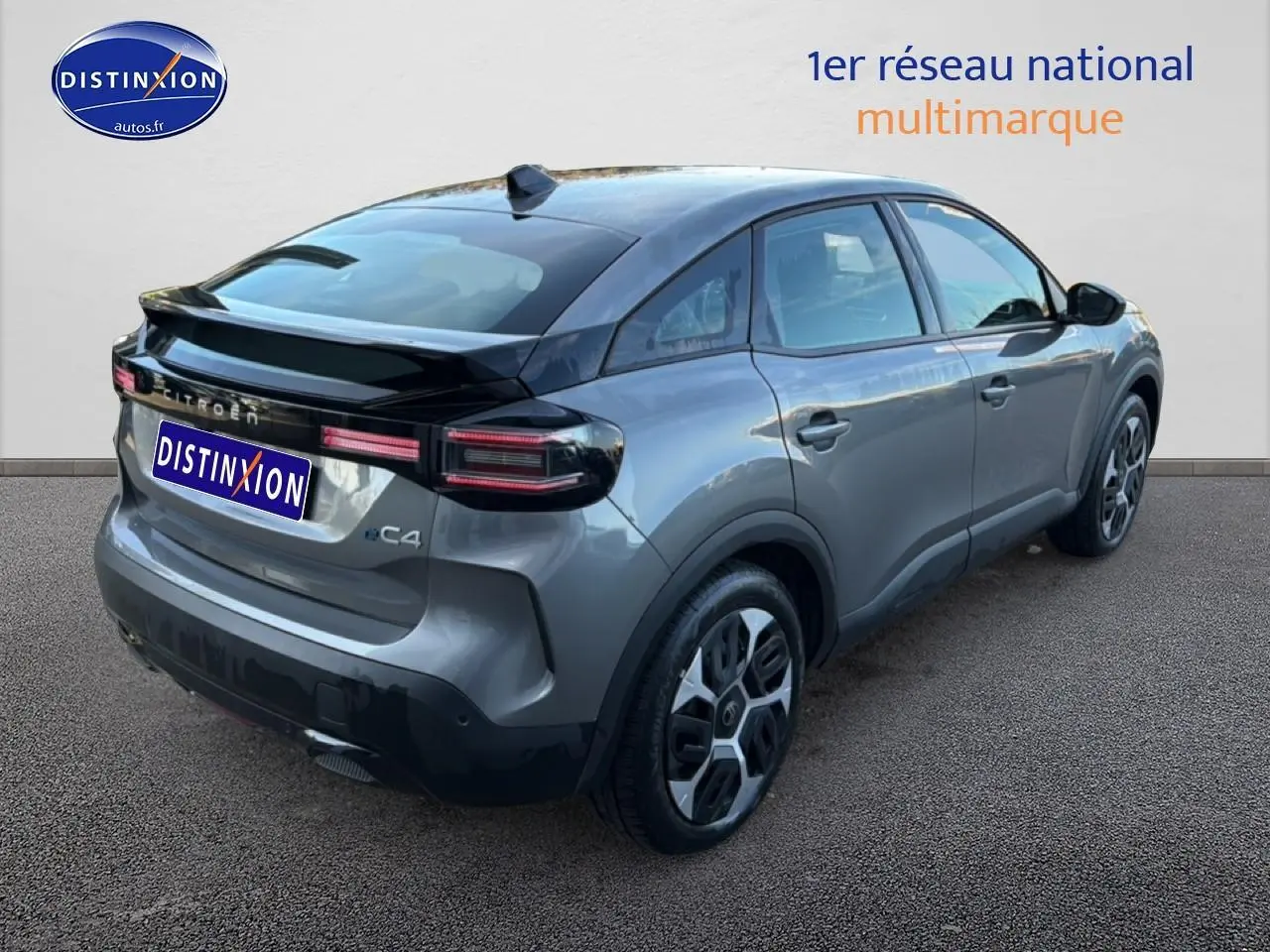 Vue 3/4 arrière droite d'une Citroën C4 électrique gris foncé avec feux arrière LED et jantes stylisées.