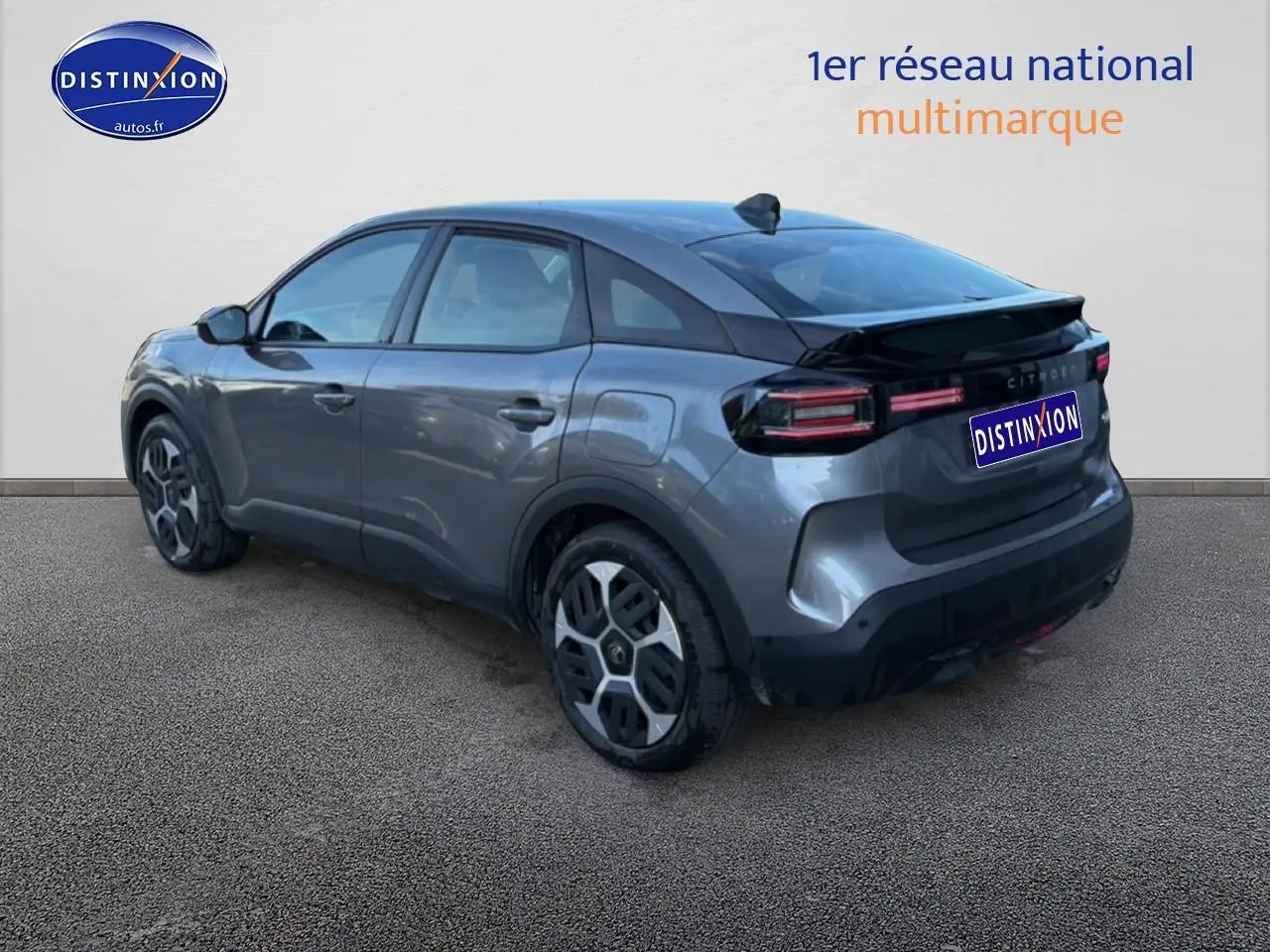 Vue 3/4 arrière droite d'une Citroën C4 électrique gris foncé avec feux arrière LED et jantes distinctives.