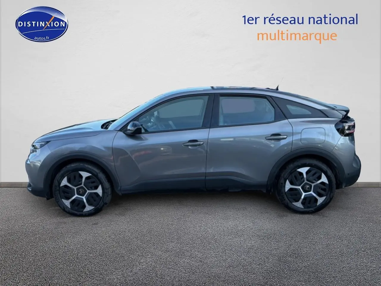 Profil côté gauche d'une Citroën C4 électrique 2025 gris foncé avec jantes distinctives et lignes fluides.