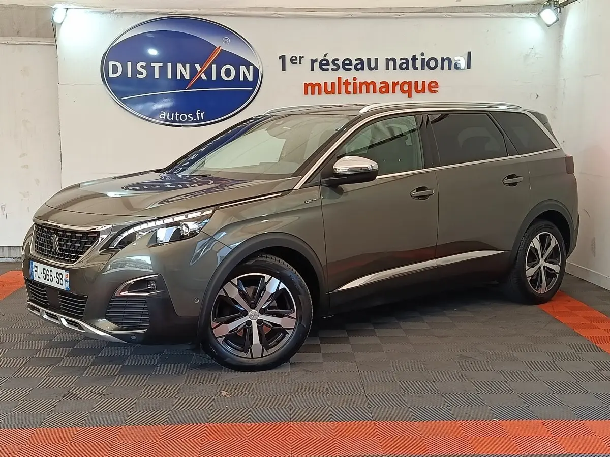Peugeot 5008 BlueHDi 180 gris clair en 3/4 avant droit, avec jantes alliage et calandre chromée visible.
