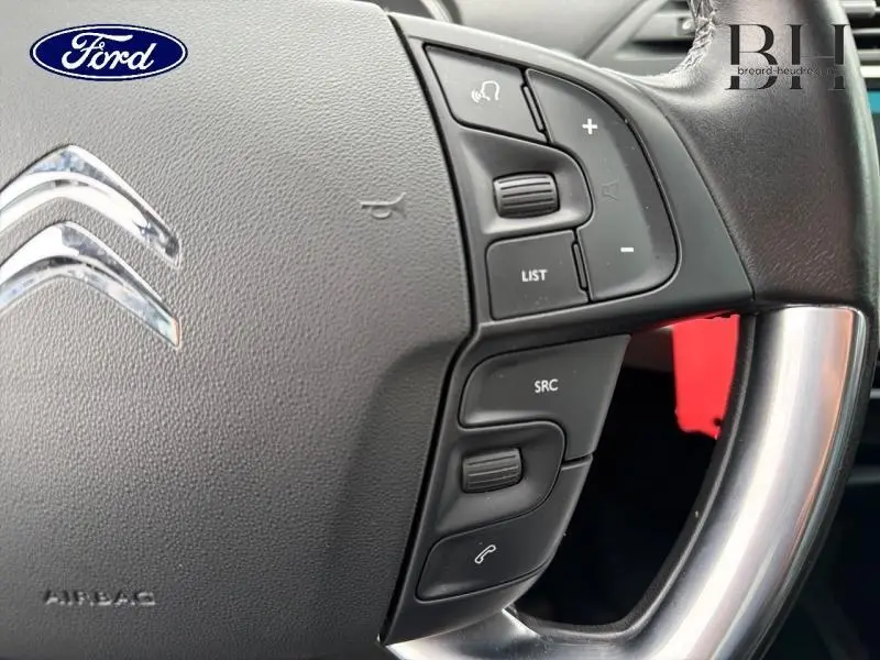 Gros plan sur le volant cuir noir de Citroën C4 Spacetourer avec commandes multifonctions côté droit, logo Citroën visible.