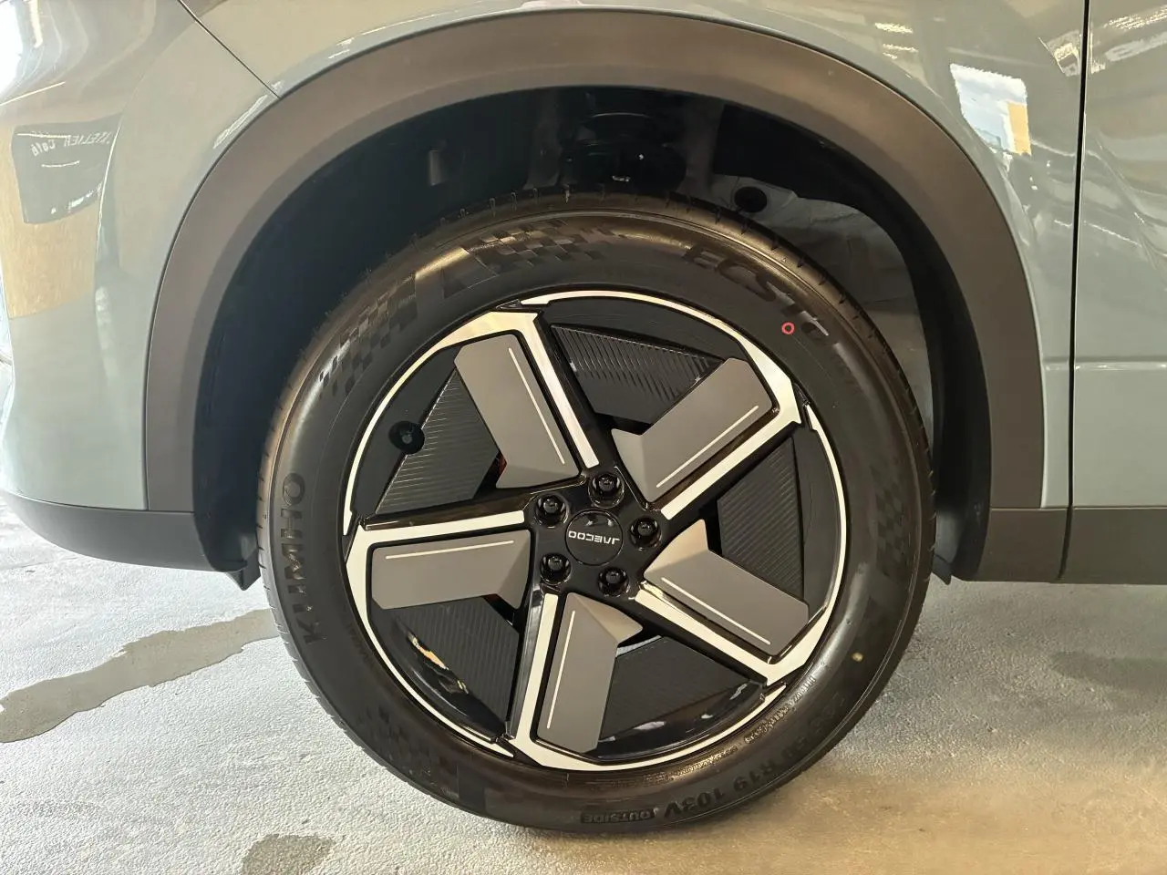 Gros plan sur la roue avant gauche du SUV JAECOO J7 2026 en gris olive, avec jante alliage noire et grise design moderne.