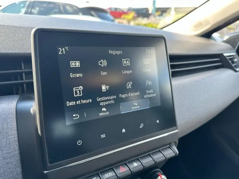 Écran tactile central vu de face dans l'habitacle d'une Renault Clio gris Rafale, avec commandes de réglages affichées.