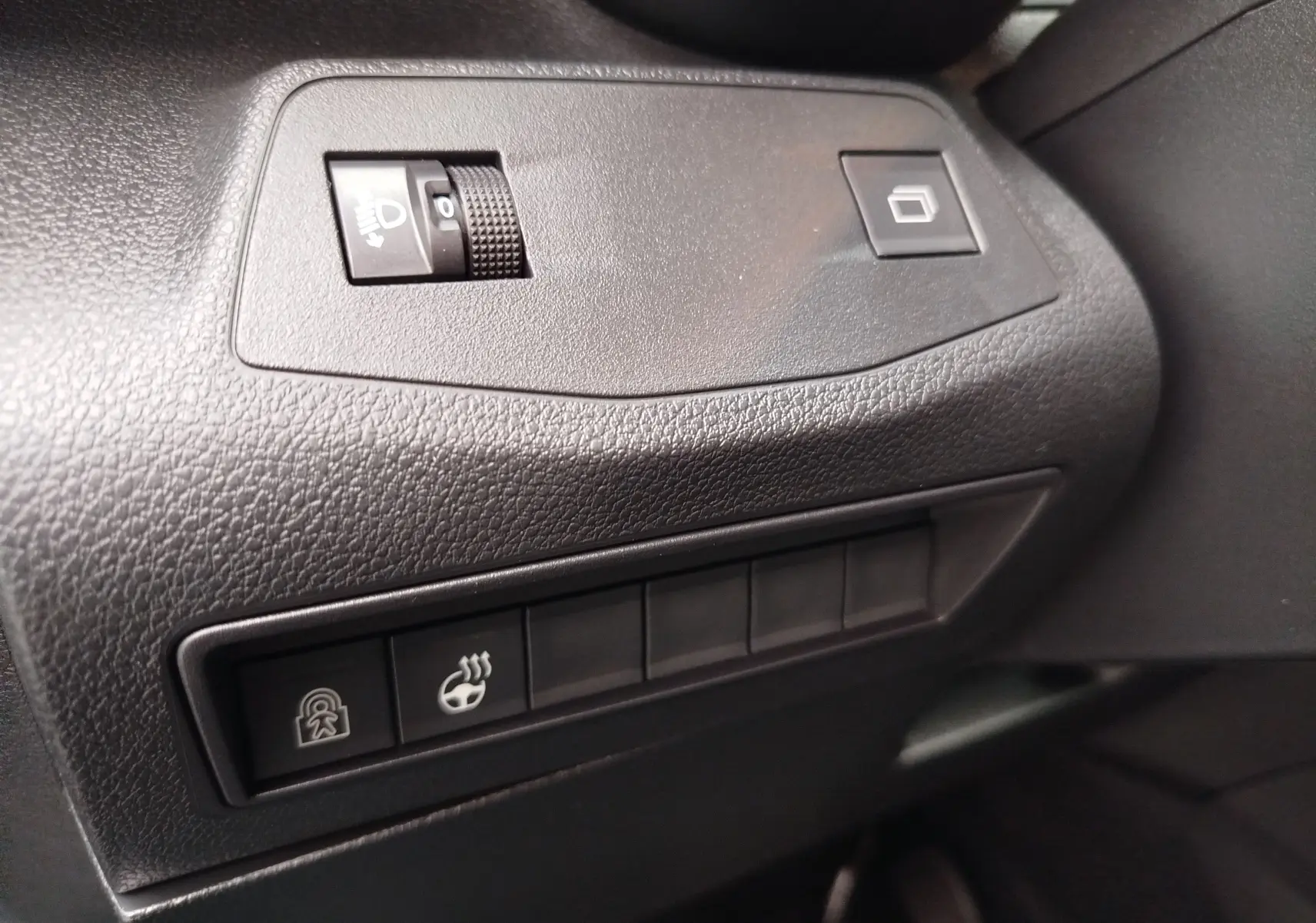 Détail des commandes noires sur le tableau de bord du Citroën Berlingo 2025, version diesel noire.