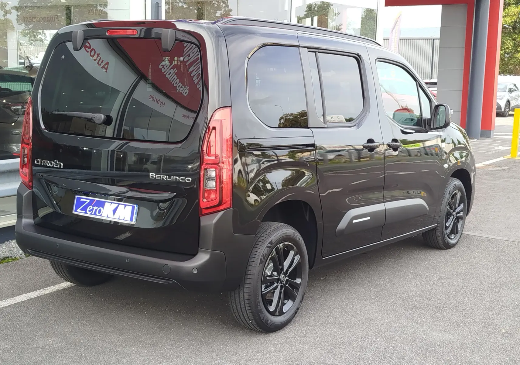 Vue 3/4 arrière droite du Citroën Berlingo noir Perla Nera avec jantes noires et vitres teintées.