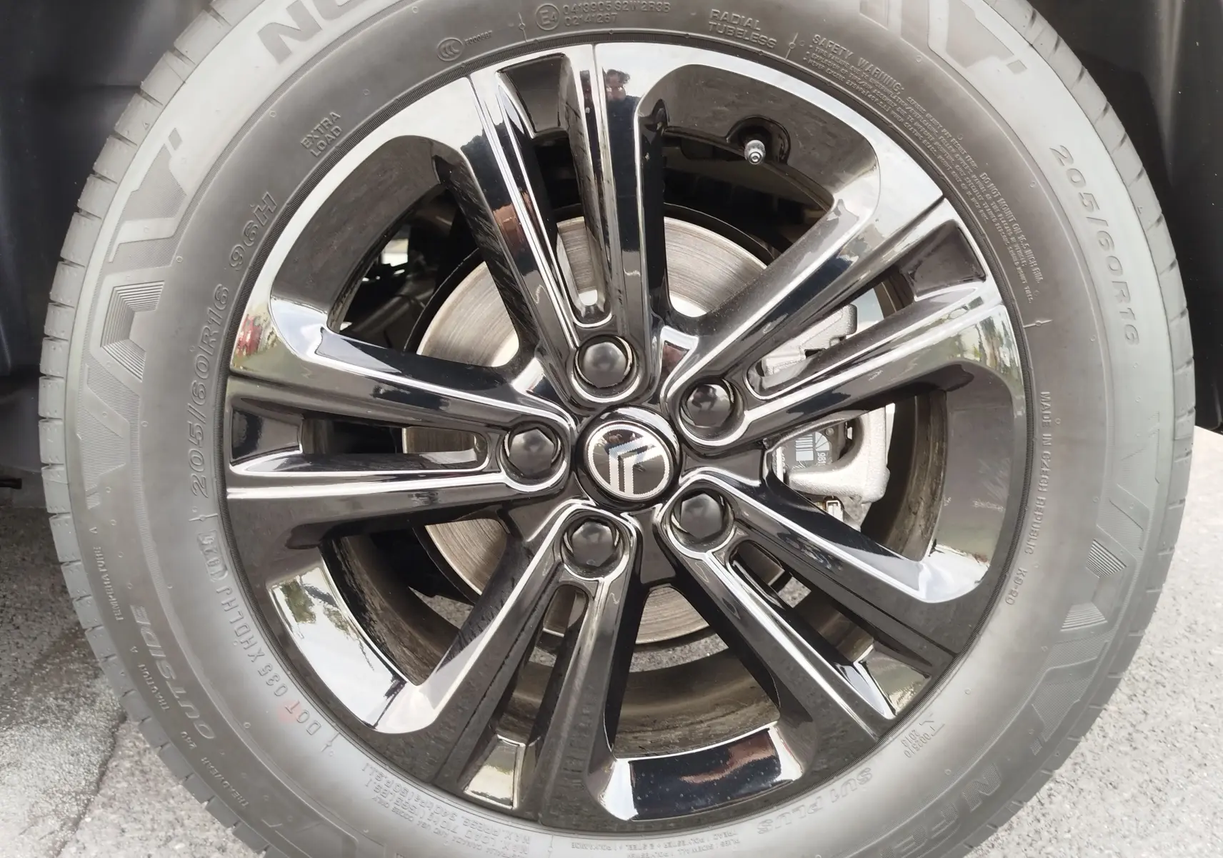 Gros plan sur la jante noire brillante et le pneu Nexen 205/60 R16 du Citroën Berlingo noir Perla Nera Metal 2025.