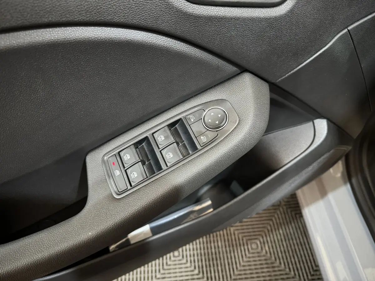 Commande des vitres électriques sur la porte côté conducteur d'une Renault Clio gris clair Evolution Blue dCi 100 -25 2025.