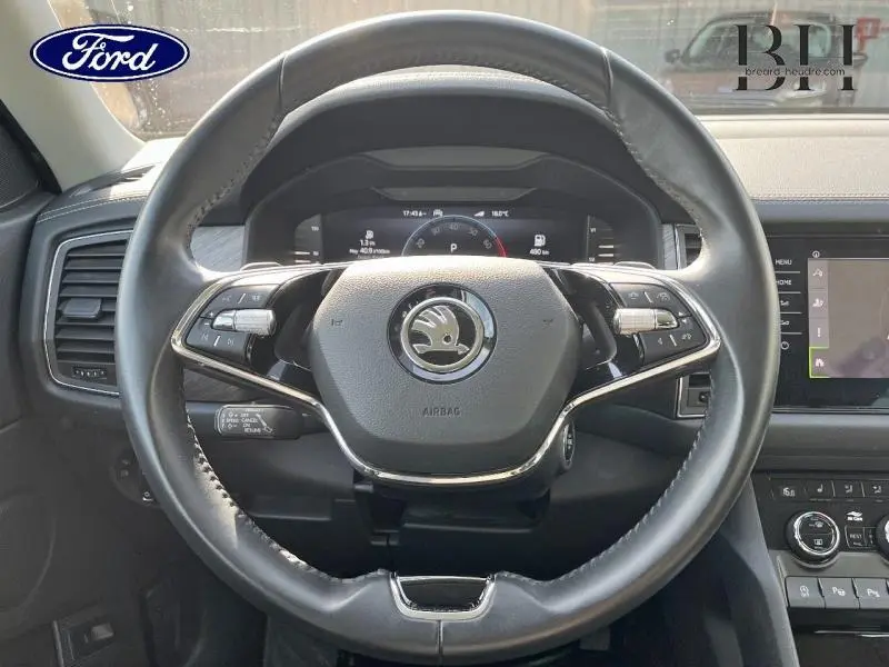 Vue rapprochée du volant cuir multifonction Skoda Kodiaq 2023 avec tableau de bord numérique et commandes intégrées.