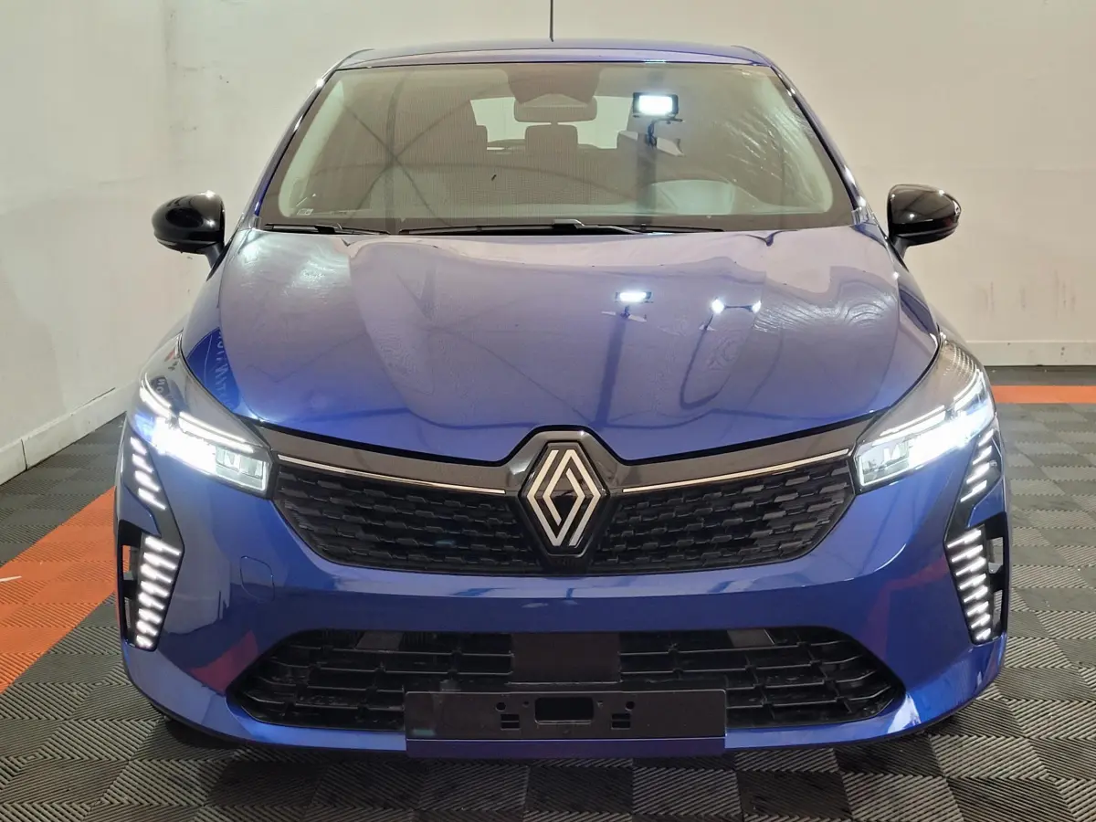 Vue frontale d'une Renault Clio Evolution Blue dCi 100 2025 en bleu avec phares LED et calandre noire distinctive.