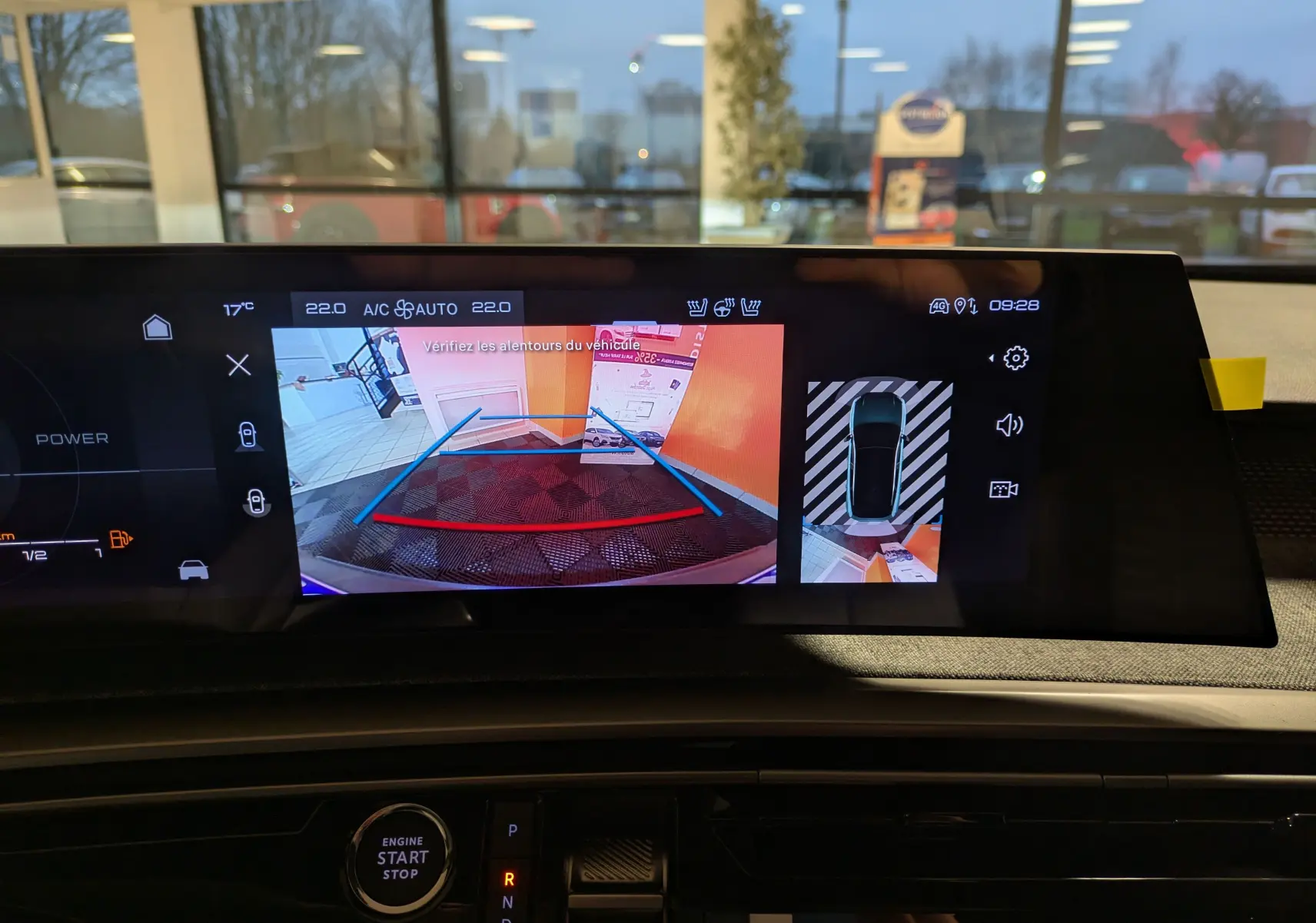 Vue intérieure du tableau de bord du Peugeot 3008 Hybrid 145 GT 2025, écran affichant la caméra de recul et l'aide au stationnement.