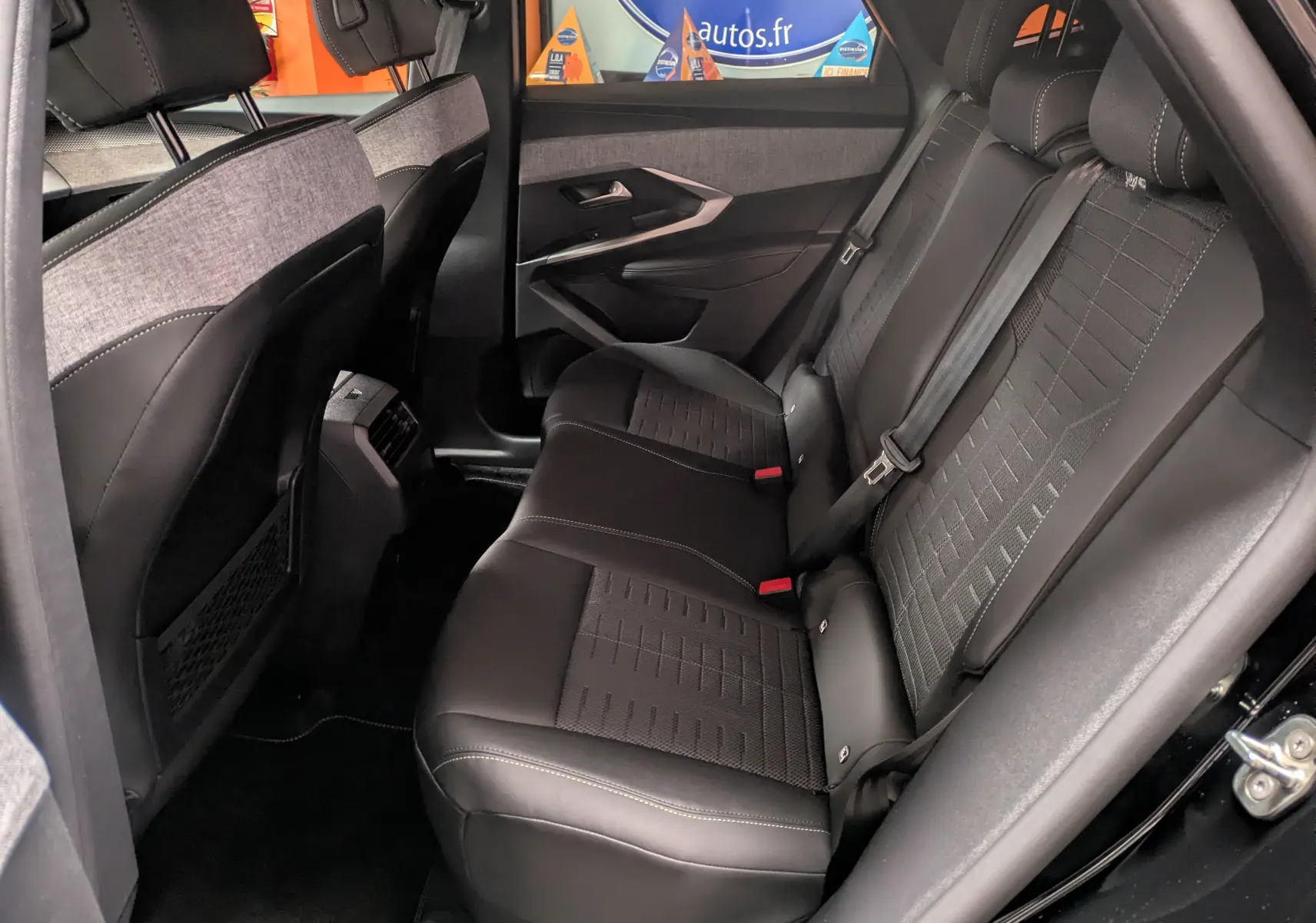 Vue intérieure côté droit des sièges arrière noirs en tissu et cuir du Peugeot 3008 Hybrid 145 E-DCS6 GT 2025.