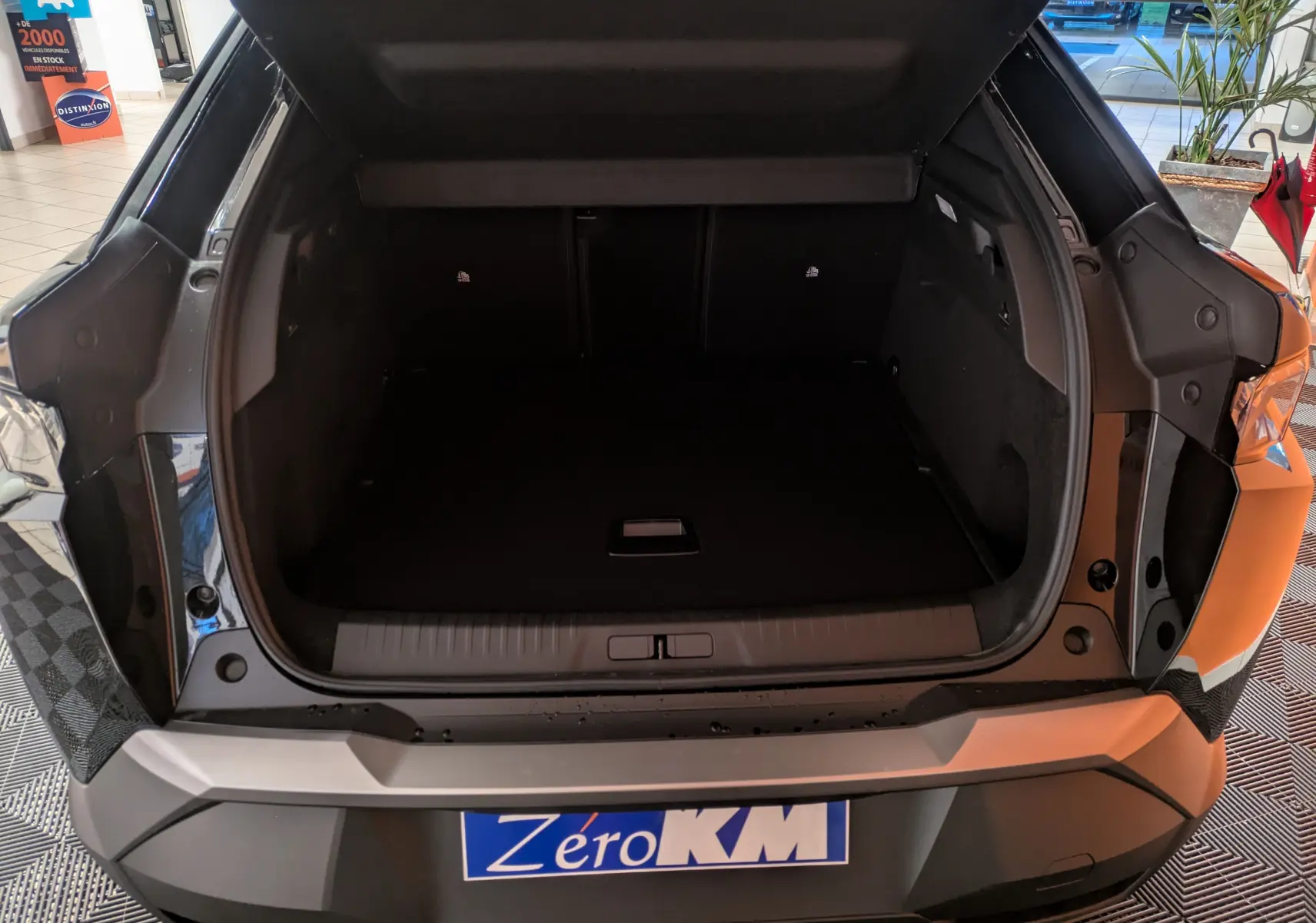 Vue arrière du coffre ouvert d’un Peugeot 3008 Hybrid 145 noir, montrant l’espace de chargement vide et le hayon relevé.