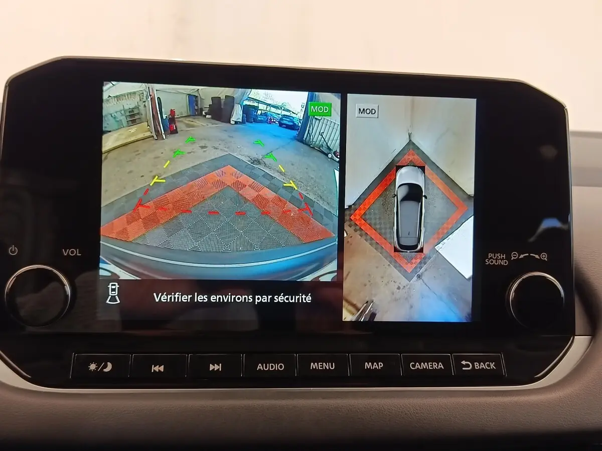 Écran tactile intérieur affichant la caméra de recul et vue à 360° du Nissan Qashqai gris foncé, tableau de bord moderne.