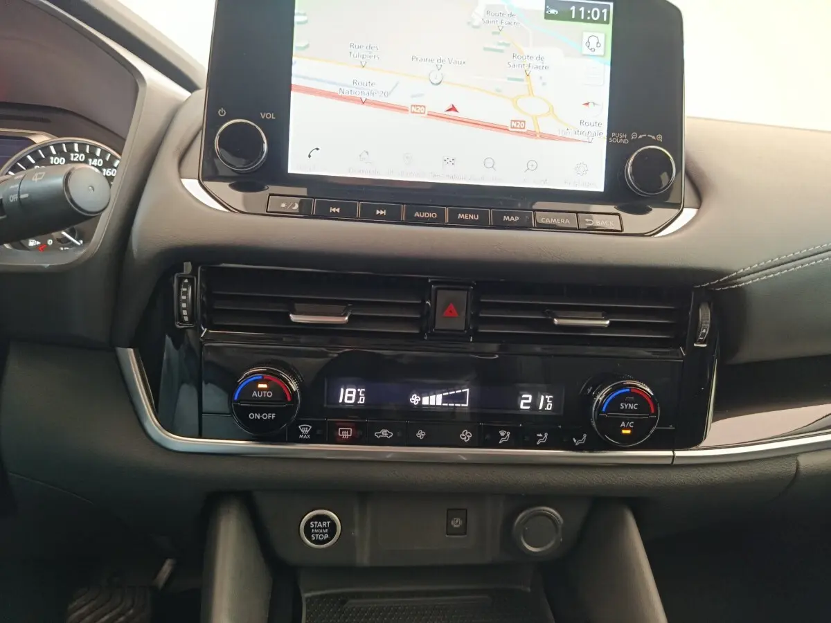 Tableau de bord central du Nissan Qashqai gris foncé 2022 avec écran tactile de navigation et commandes climatisation digitales.
