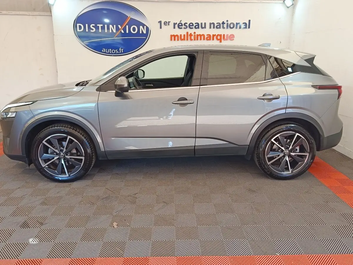 Vue de profil côté gauche du Nissan Qashqai gris foncé 2022, avec jantes alliage et toit contrasté noir.
