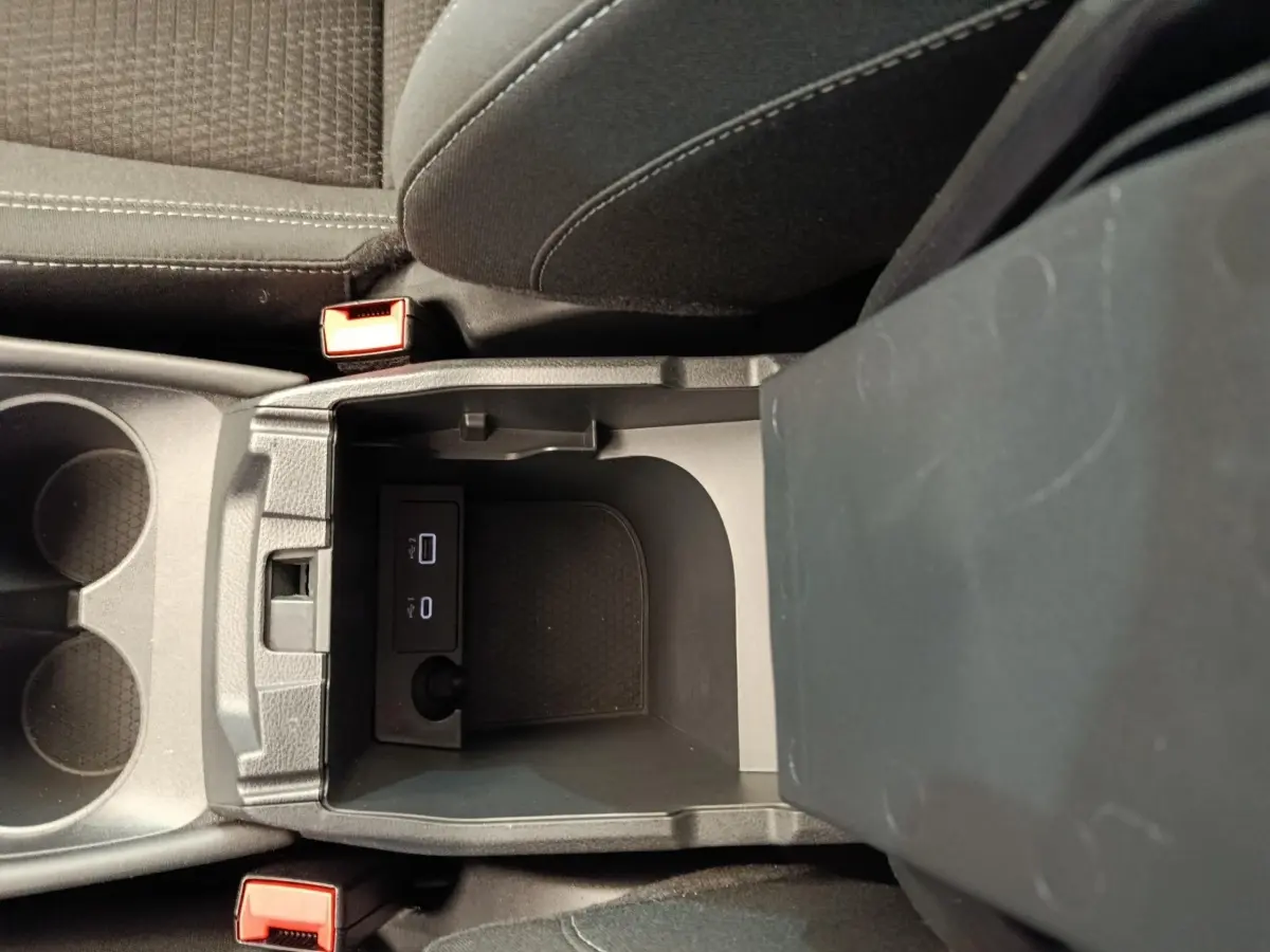 Vue plongeante sur la console centrale du Nissan Qashqai gris foncé, avec ports USB et porte-gobelets visibles.