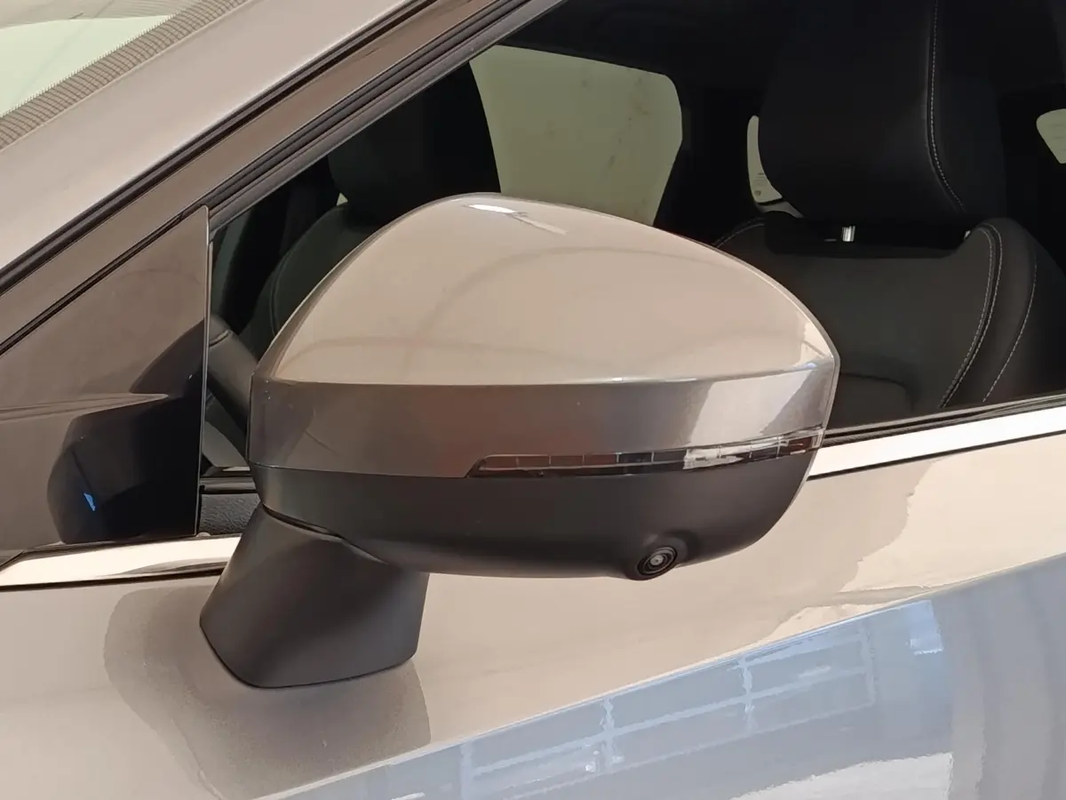 Rétroviseur côté gauche gris foncé du Nissan Qashqai 2022 avec caméra intégrée et clignotant LED.