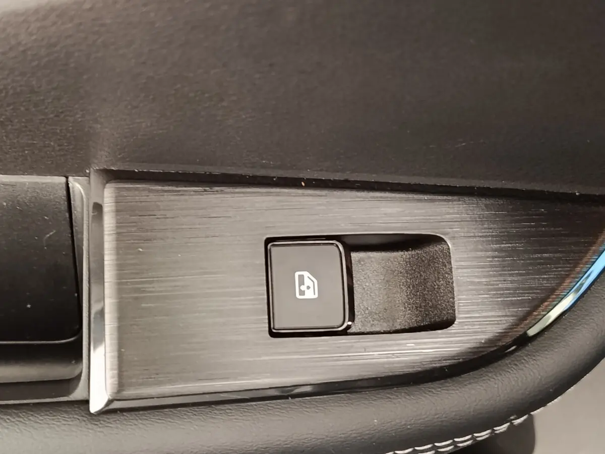 Bouton de commande de lève-vitre électrique sur panneau de porte intérieur noir du Nissan Qashqai gris foncé 2022.