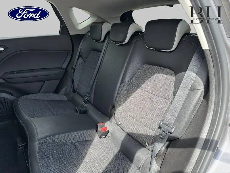 Vue intérieure côté droit des sièges arrière noirs et gris du Renault Captur 2022, avec ceintures de sécurité visibles.