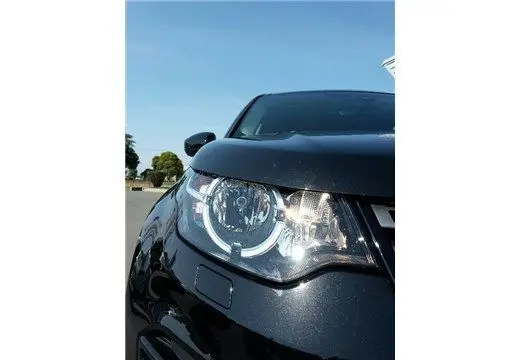 Gros plan sur le phare avant gauche d'un Land Rover Discovery Sport noir de 2017, mettant en valeur son design moderne.