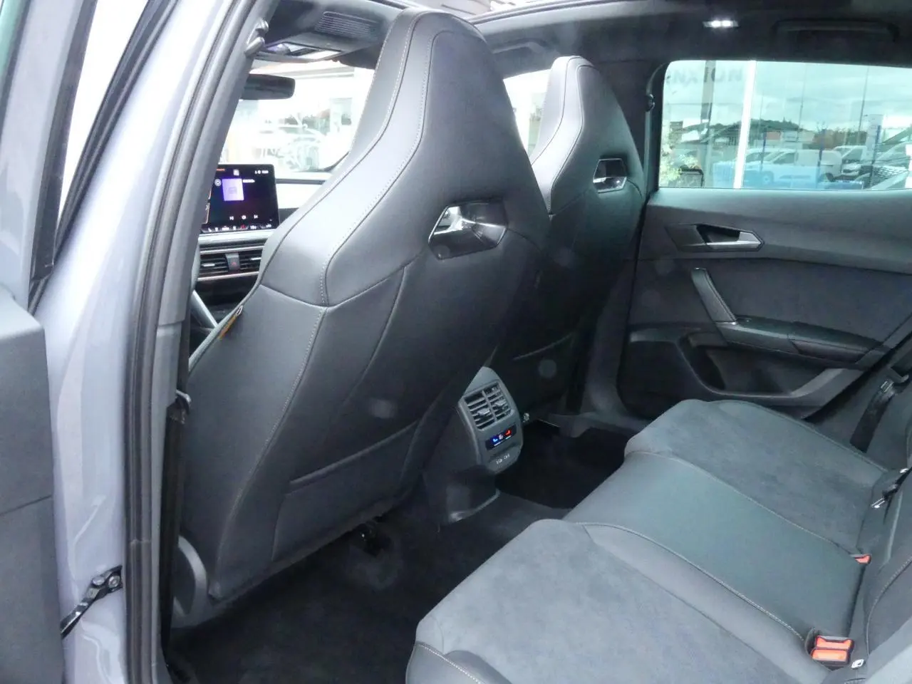 Vue arrière intérieure du CUPRA Formentor gris Graphène, sièges arrière en suédine noire avec contre-portes assorties.