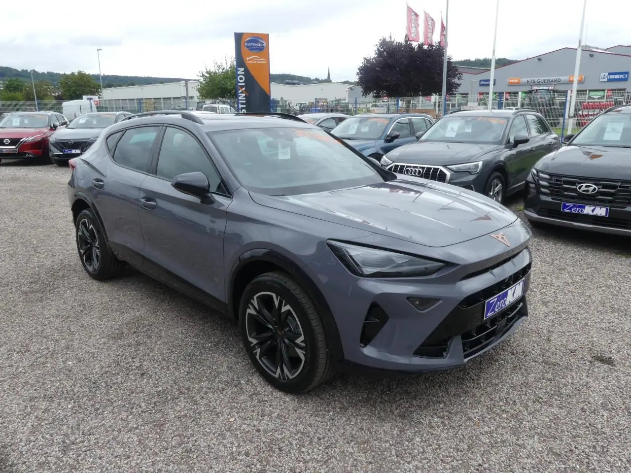 SUV CUPRA Formentor gris Graphène vu en 3/4 avant droit avec jantes noires et coques de rétroviseurs noires.