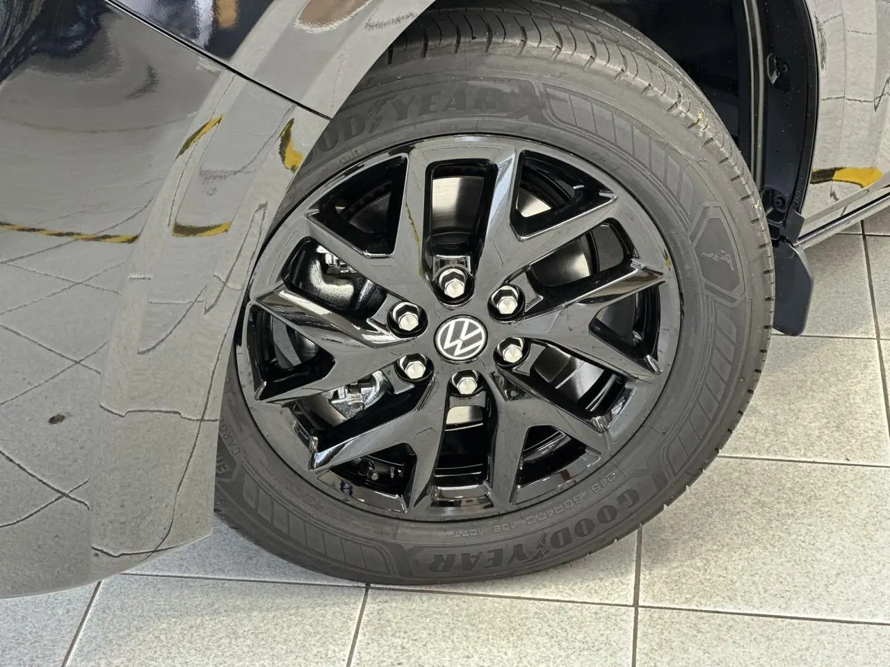 Gros plan sur la jante alliage noir brillant Le Mans 17 pouces du côté avant gauche du Volkswagen Transporter T7 noir Minuit.