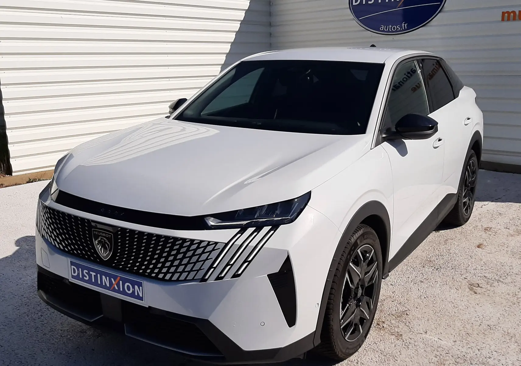 Peugeot 3008 Hybrid blanc Okenite en 3/4 avant droit, avec calandre distinctive et jantes noires.