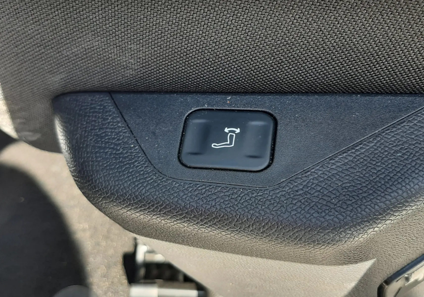 Bouton de réglage électrique du siège en gros plan à l'intérieur du Peugeot 3008 blanc Okenite 2024.