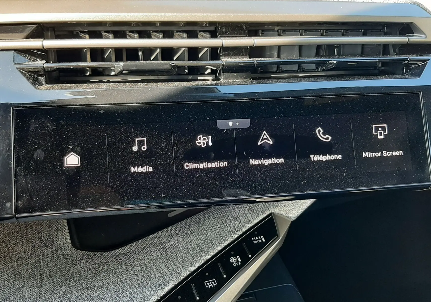 Vue rapprochée de la console centrale du Peugeot 3008 Hybrid 2024, écran tactile avec options multimédia et climatisation.